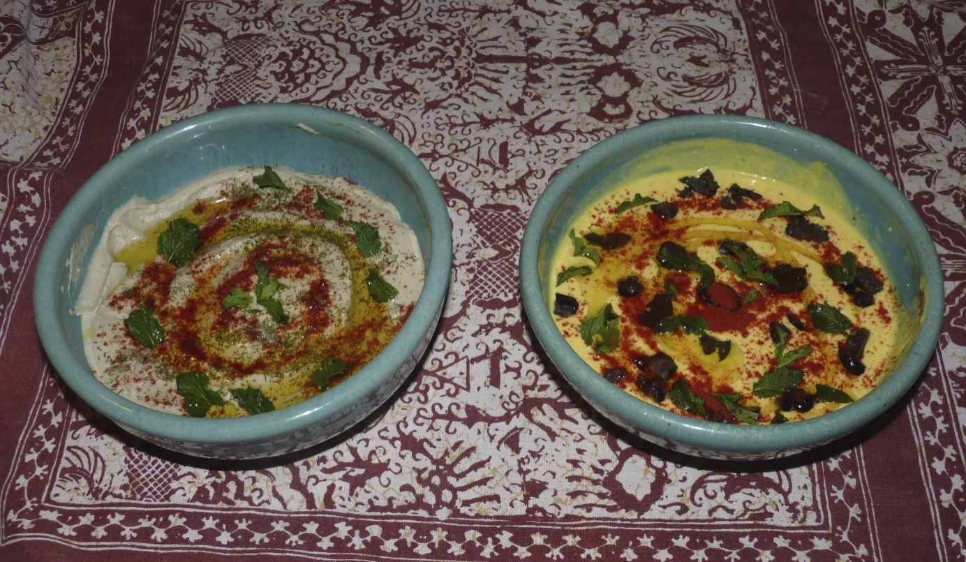 Baba ganoush garnished with dill, mint and paprika; humus garnished with mint, paprika and black olives. The addition of fresh turmeric to the humus gives it a lovely golden colour.