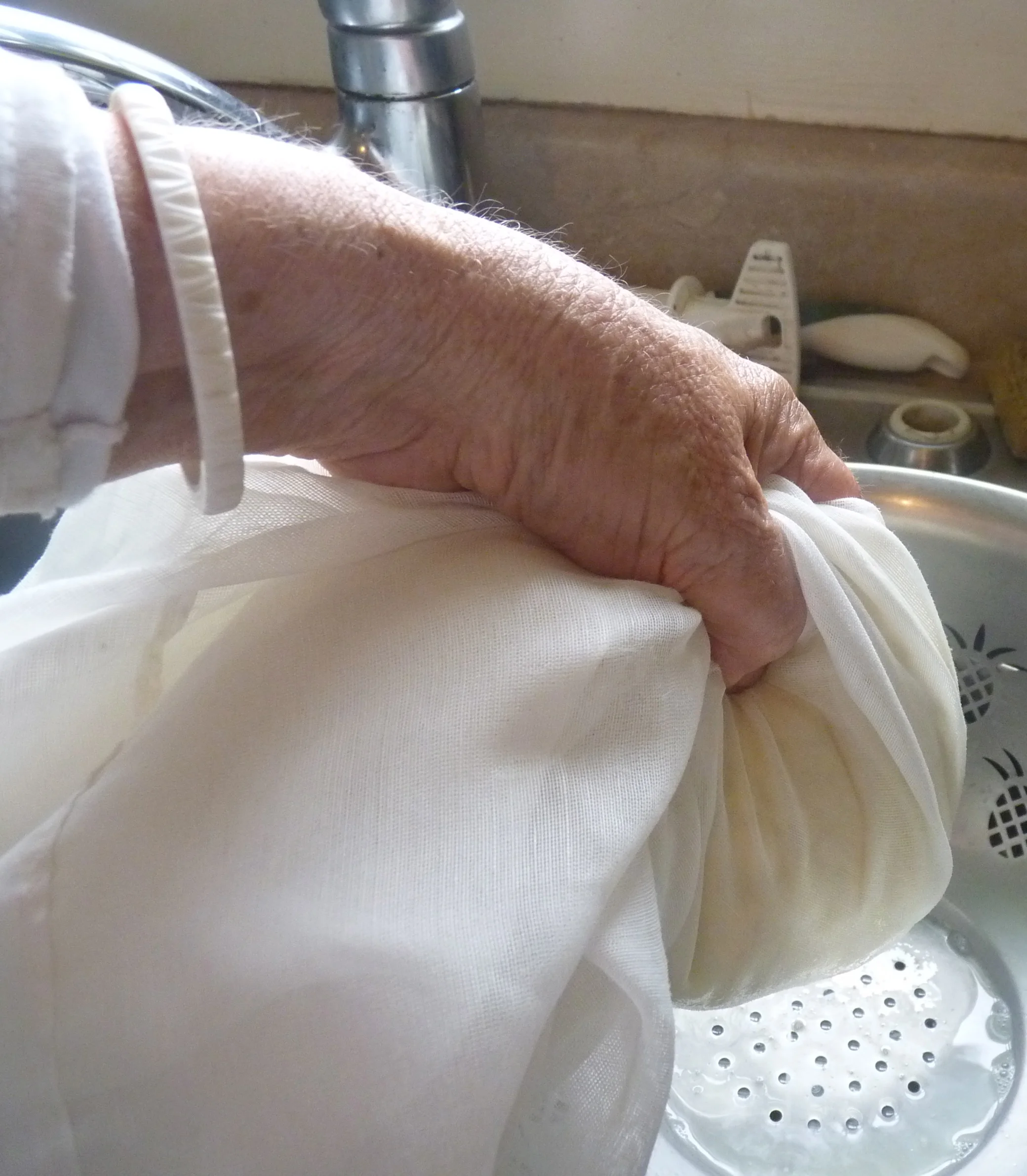 Gather the cheesecloth and squeeze out the whey.