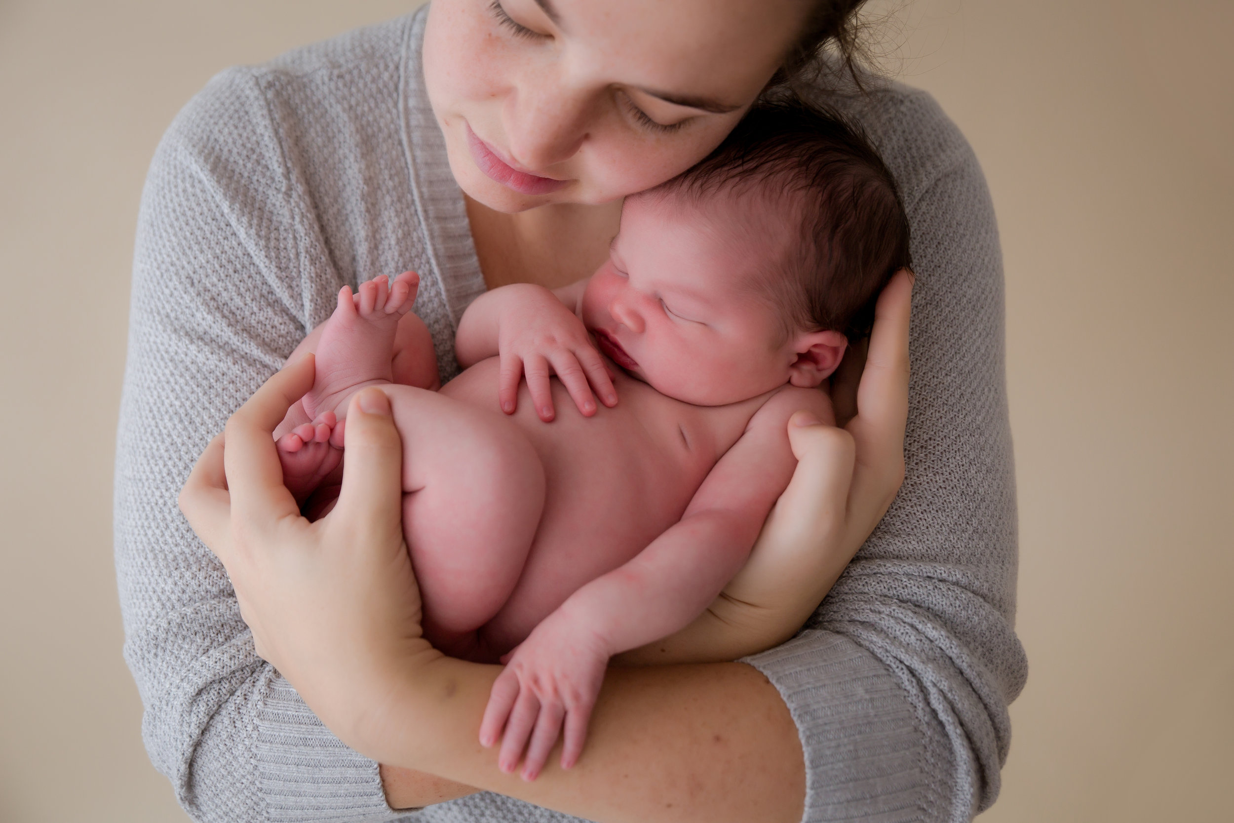 mom holding naked newborn baby girl