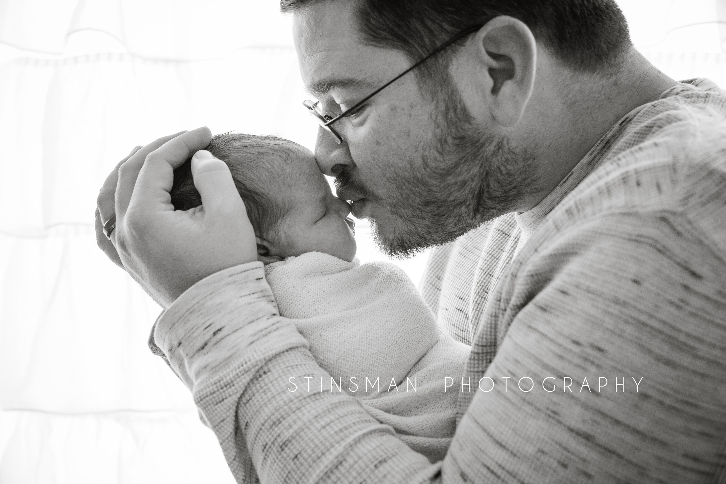 new dad kissing his little girl in black and white