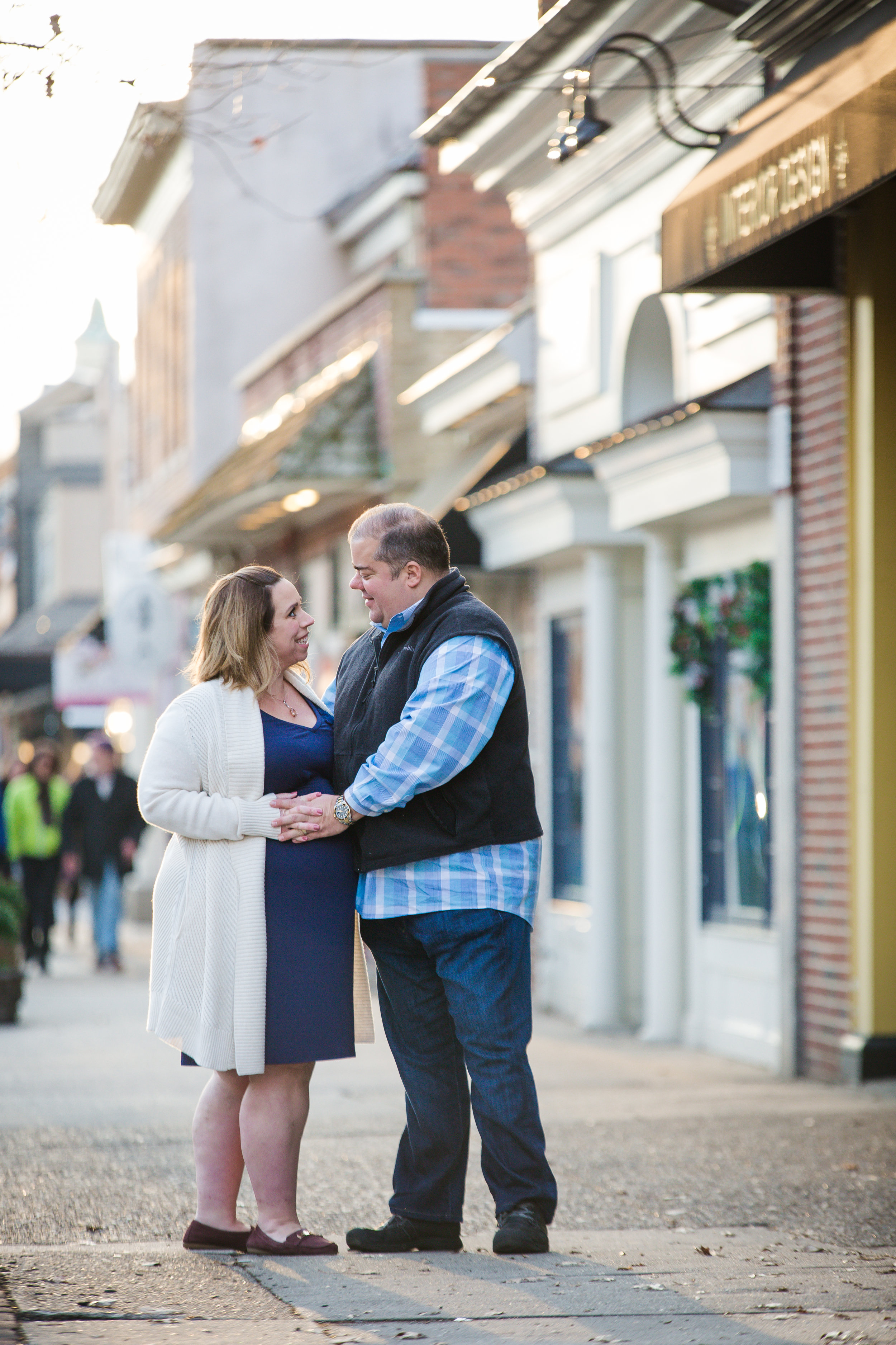 couple holding hands on a pregnant belly in haddonfield nj