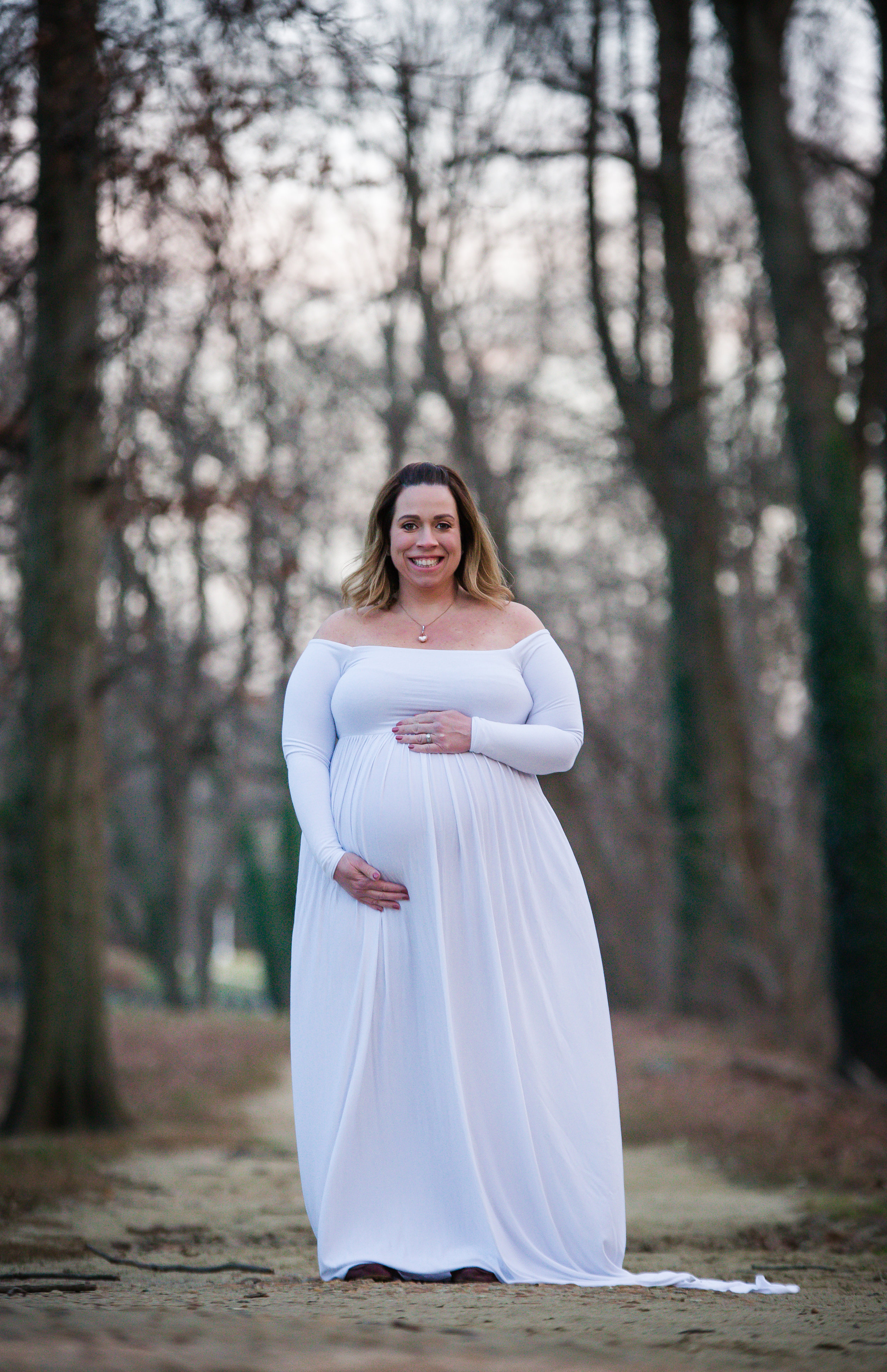 pregnant photo wearing a white dress in the winter time