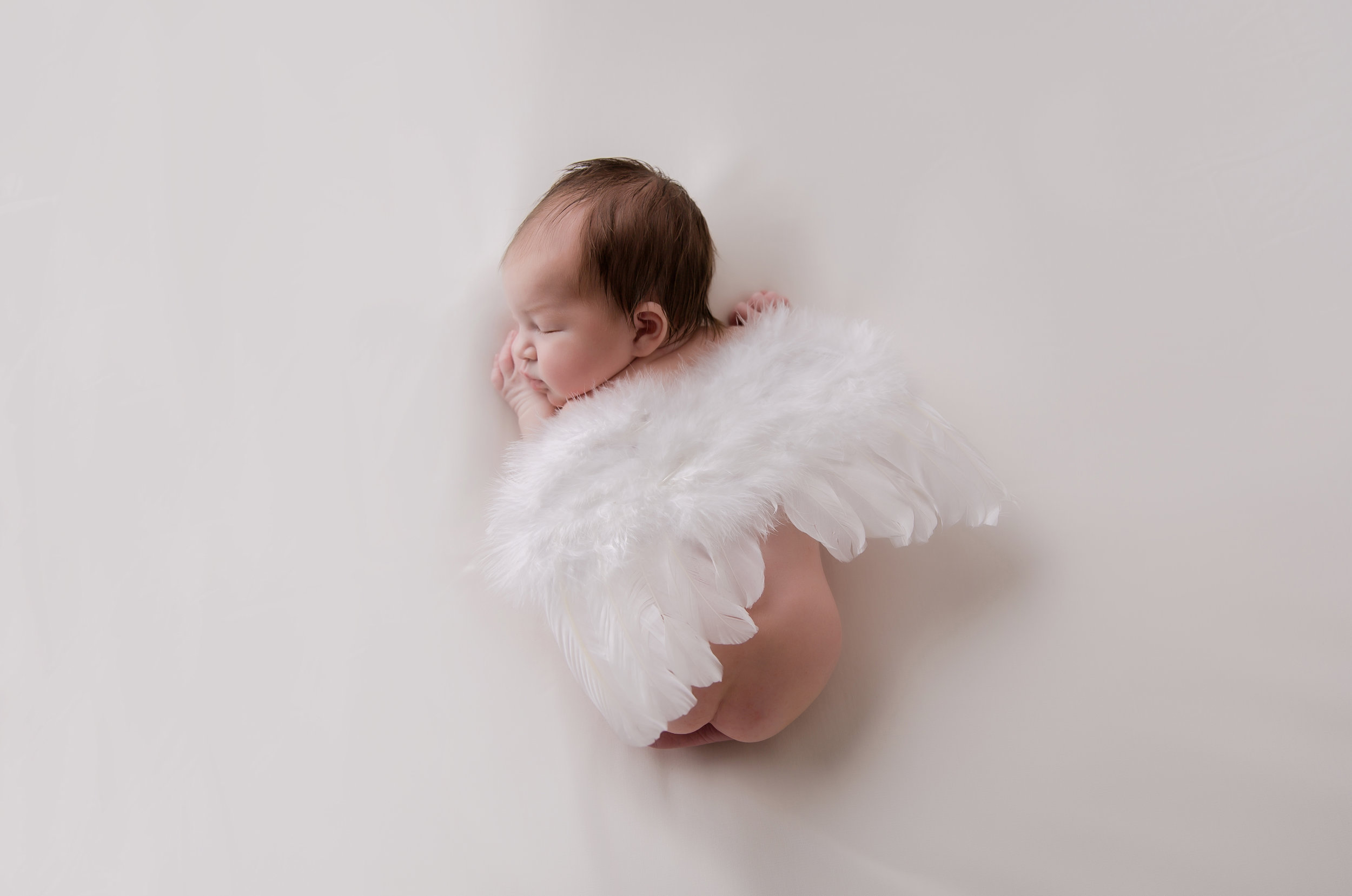 photo of a baby wearing angel wings