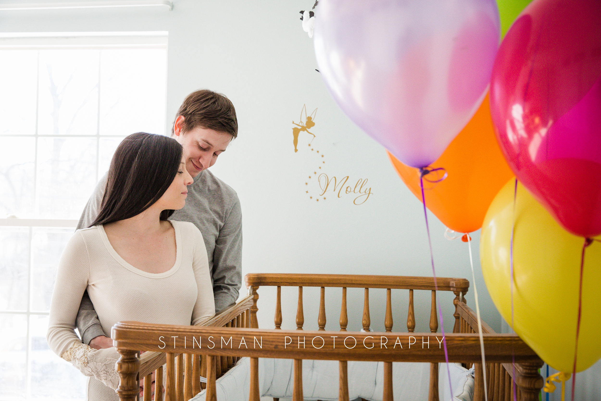 nursey maternity photo with rainbow balloons for a rainbow baby in new jersey
