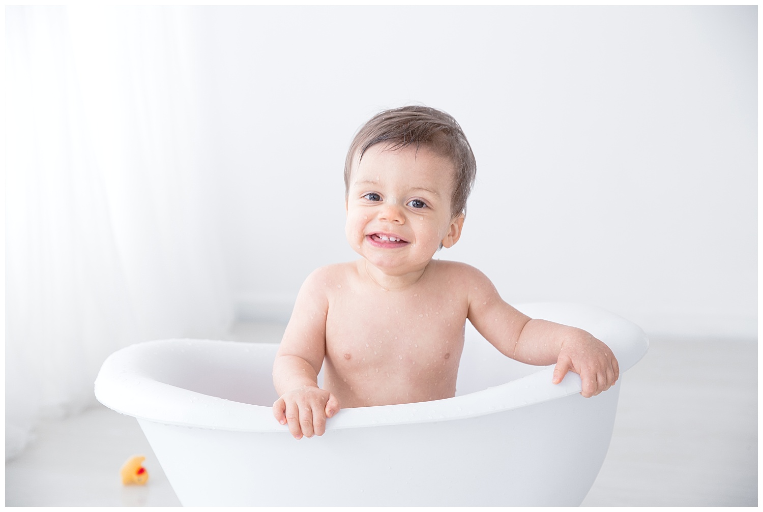 big smile in the tub during first birthday photo shoot in burlington new jersey