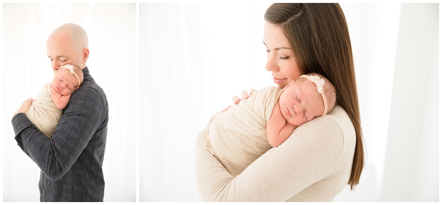 mom and dad snuggling their newborn baby girl for her baby photos in burlington new jersey
