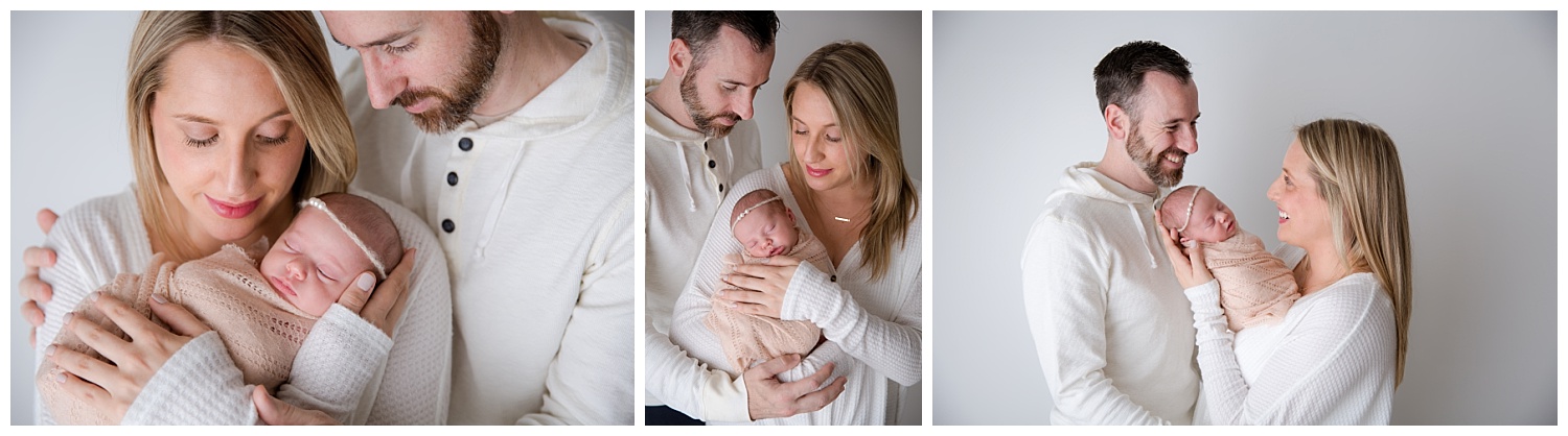 mom and dad snuggling their newborn baby girl in photos in burlington new jersey studio