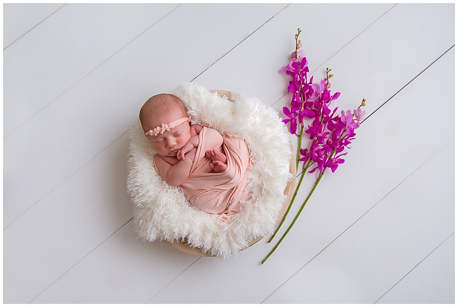 orchids surrounding a baby girl in moorestown new jersey photo studio