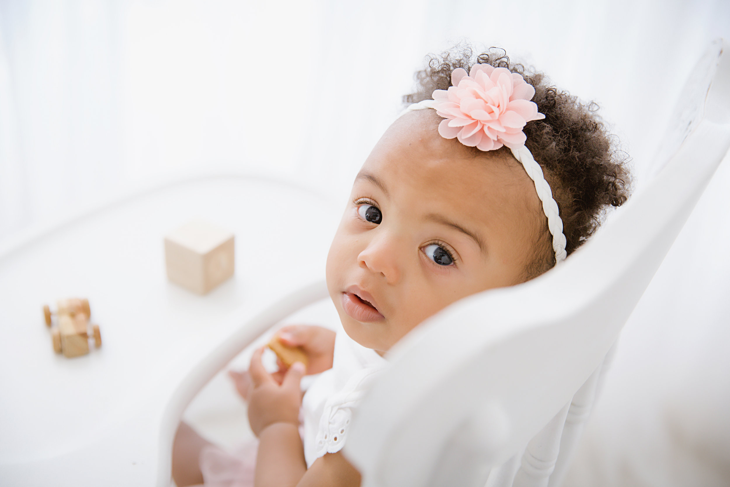 baby-girl-first-birthday-shoot-sitting-in-high-chair-playing-with-blocks-photography-shoot-burlington-new-jersey