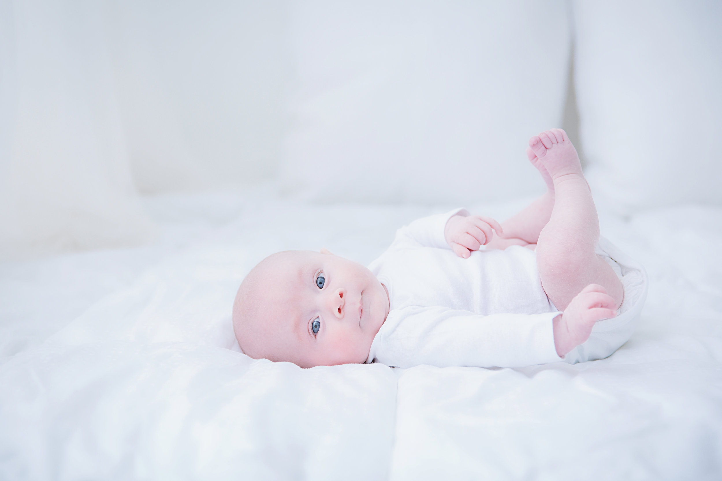 studio-photography-3-month-old-baby-lying-down-white-bed-sheets-new-jersey