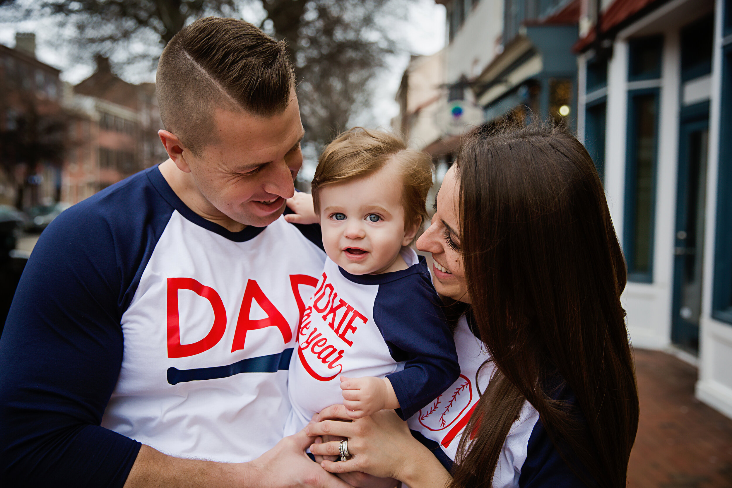 one-year-old-boy-smiling-with-parents-during-his-first-birthday-photoshoot-outside