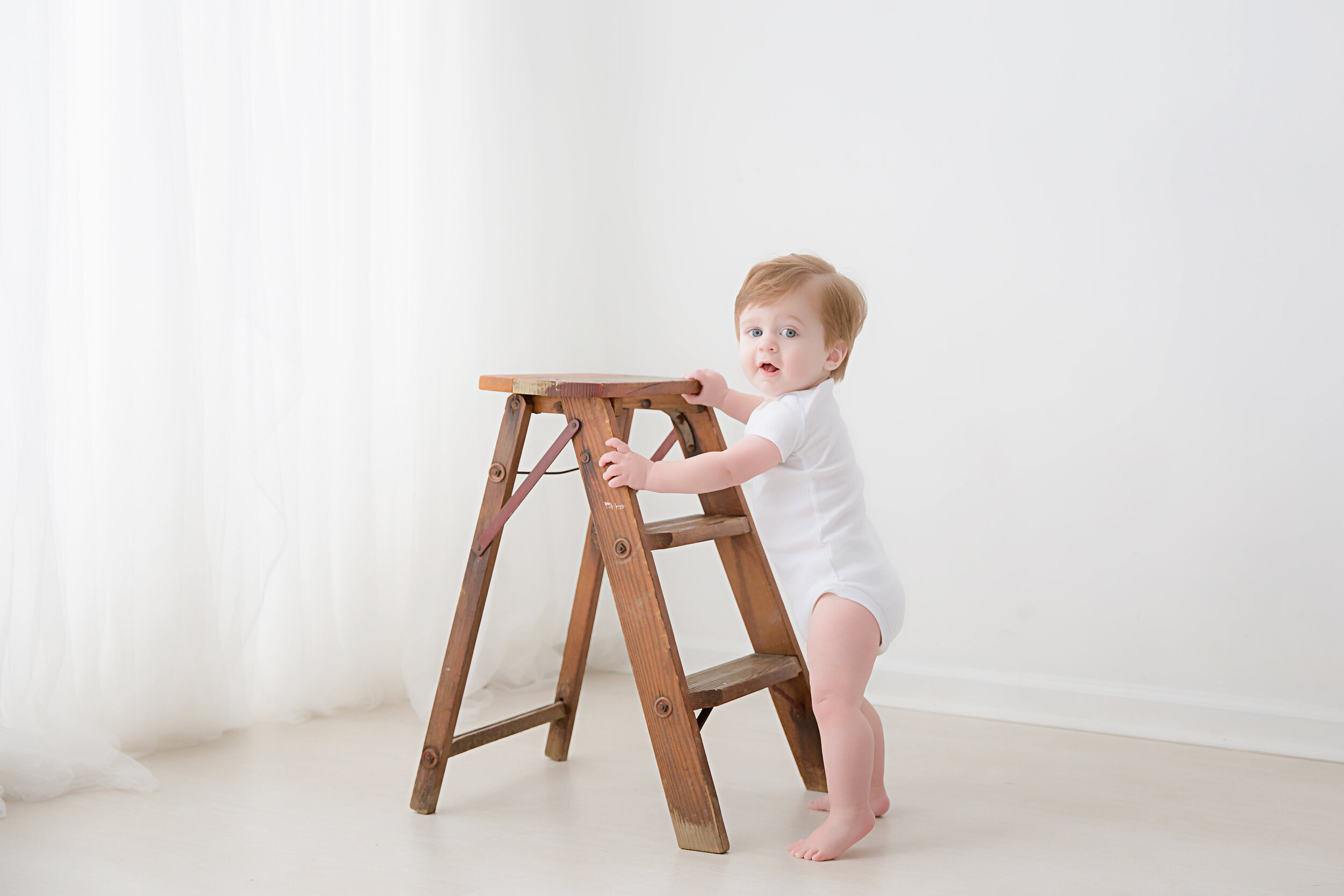 first-birthday-baby-boy-standing-with-ladder