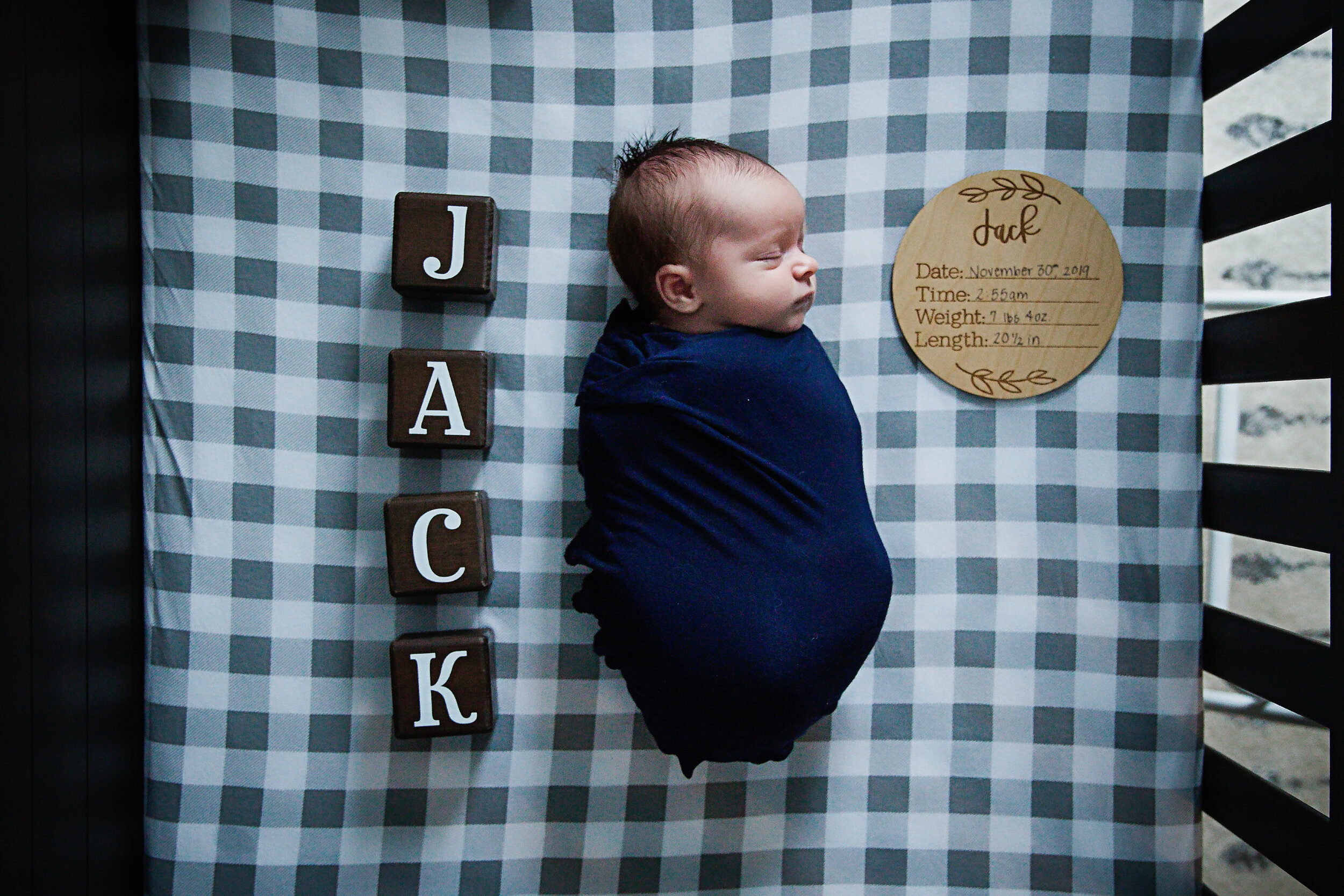 newborn-baby-boy-swaddled-in-blue-sleeping-in-crib