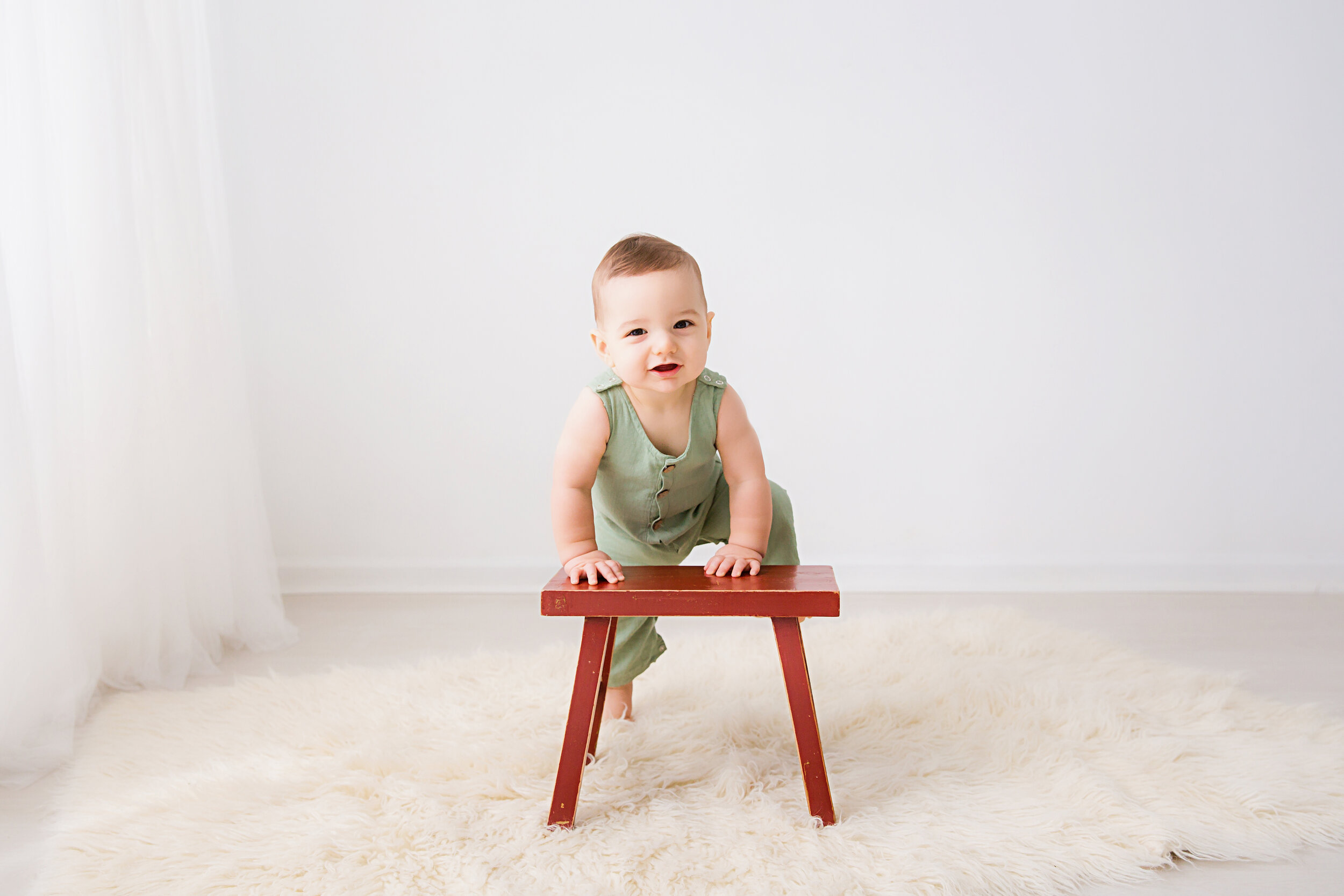 first-birthday-boy-climbing-on-wooden-stool