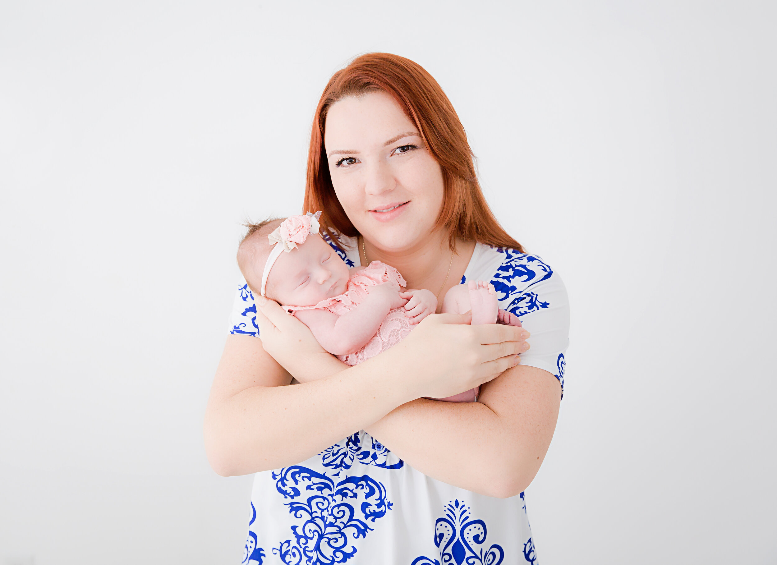 mom-holding-newborn-baby-girl-in-studio