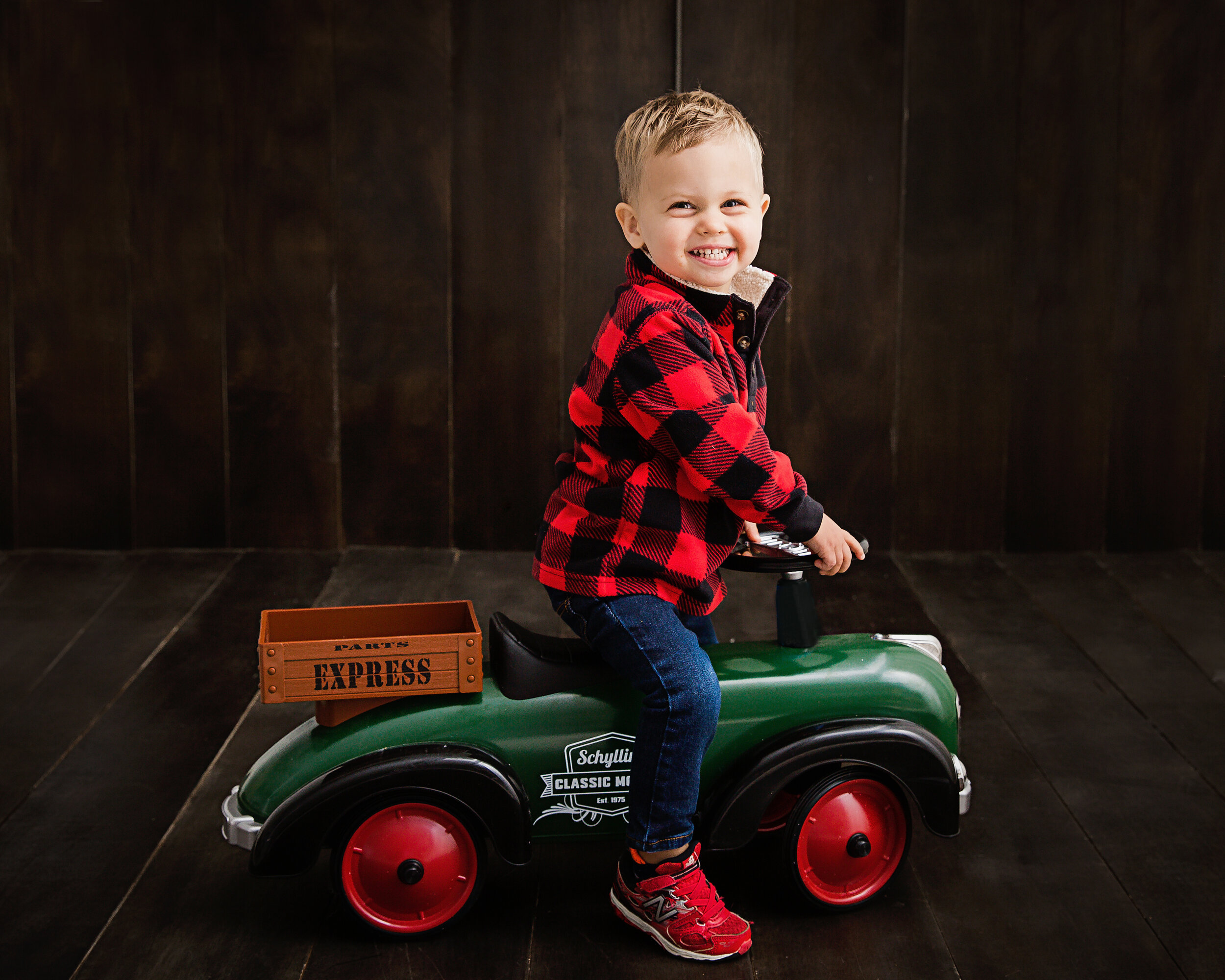 little-boy-smiling-while-riding-little-green-car