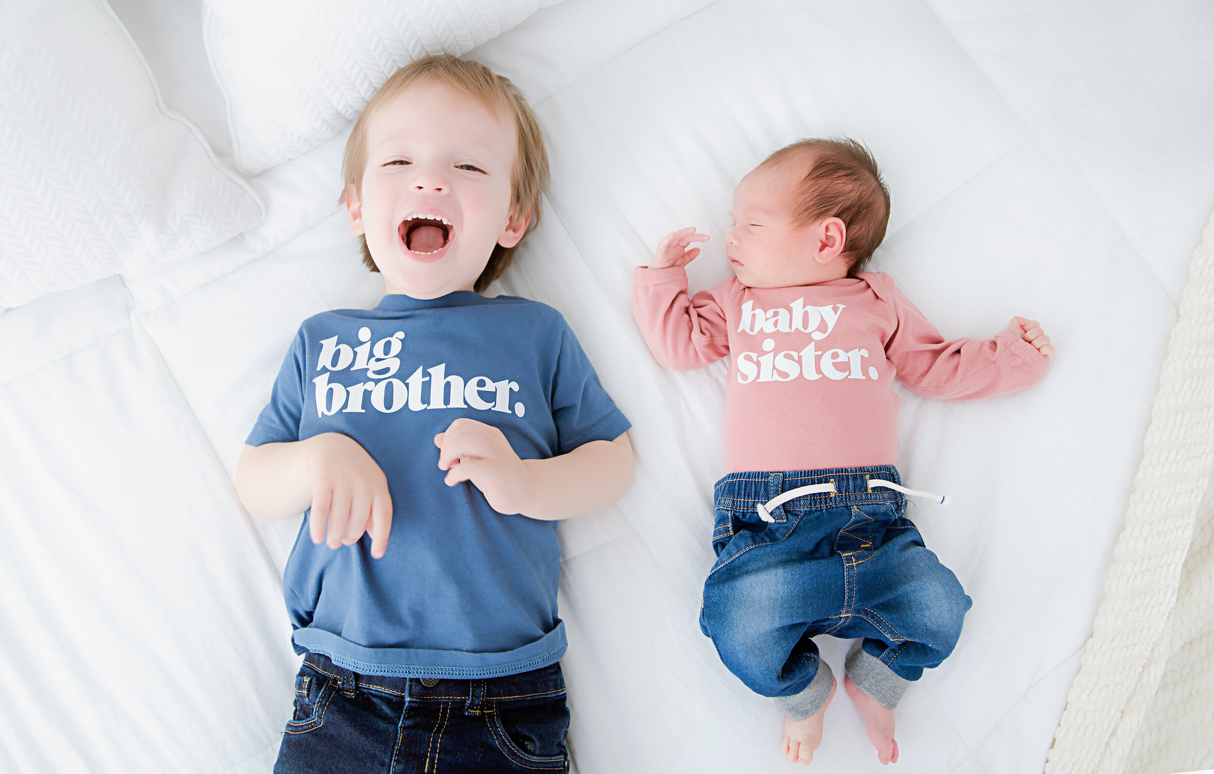 big-brother-and-baby-sister-laying-down-on-bed