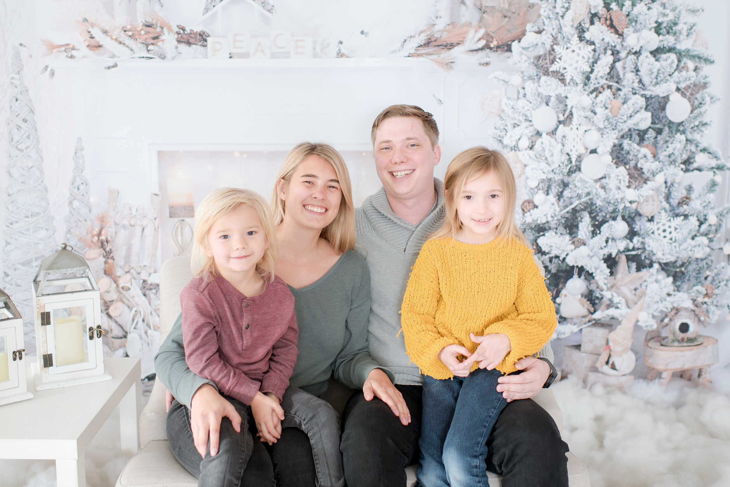 family-of-four-smiling-and-looking-at-camera-for-winter-photography-session