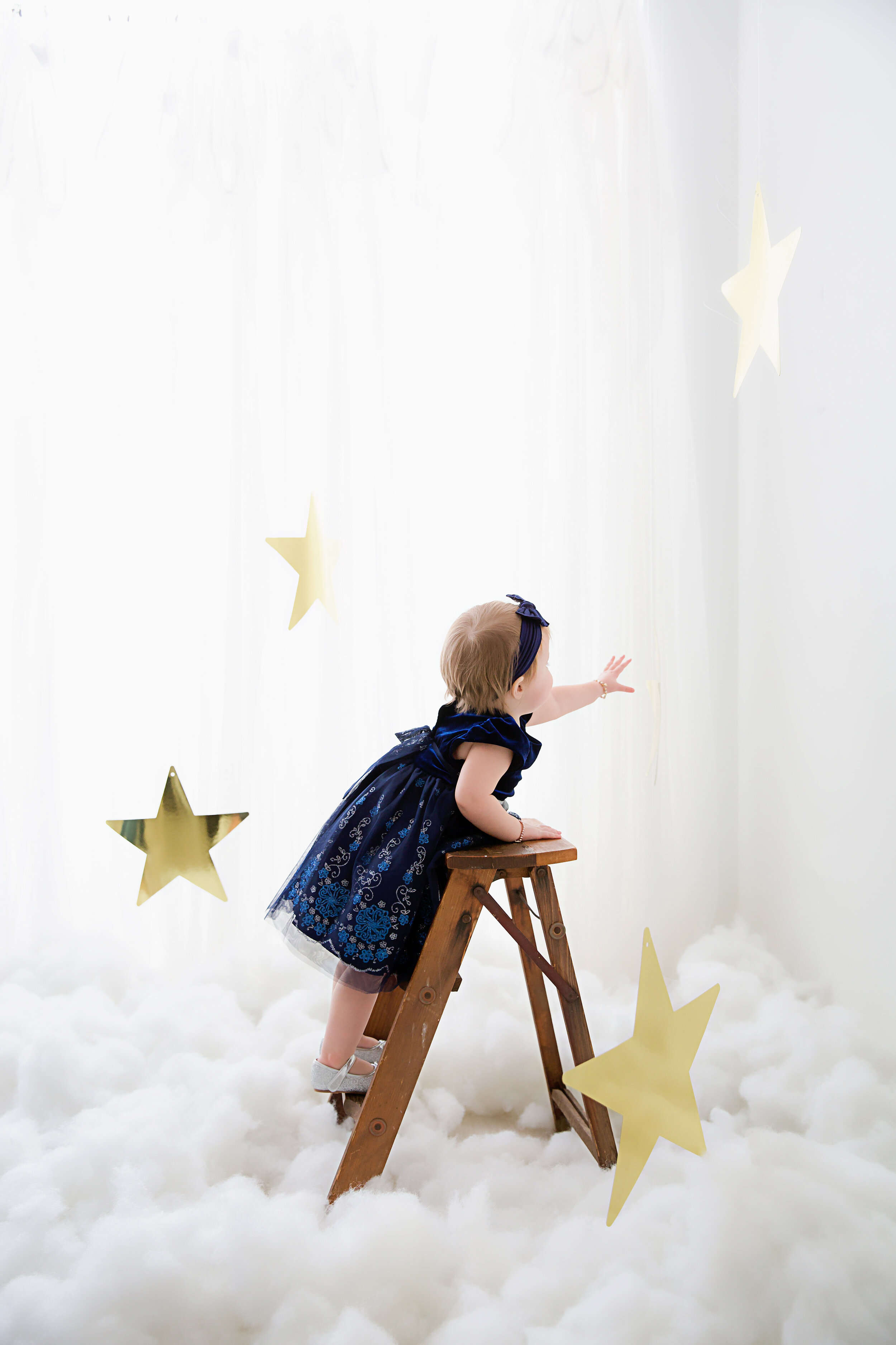 baby girl climbing a ladder reaching for the stars