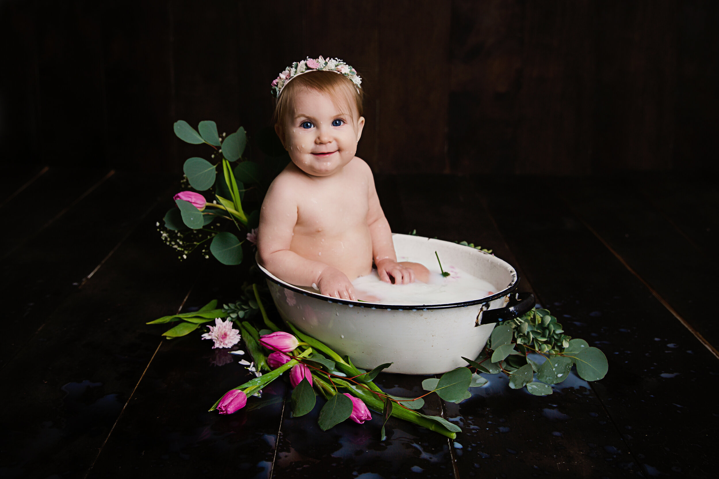 smiling baby girl in a milk bath