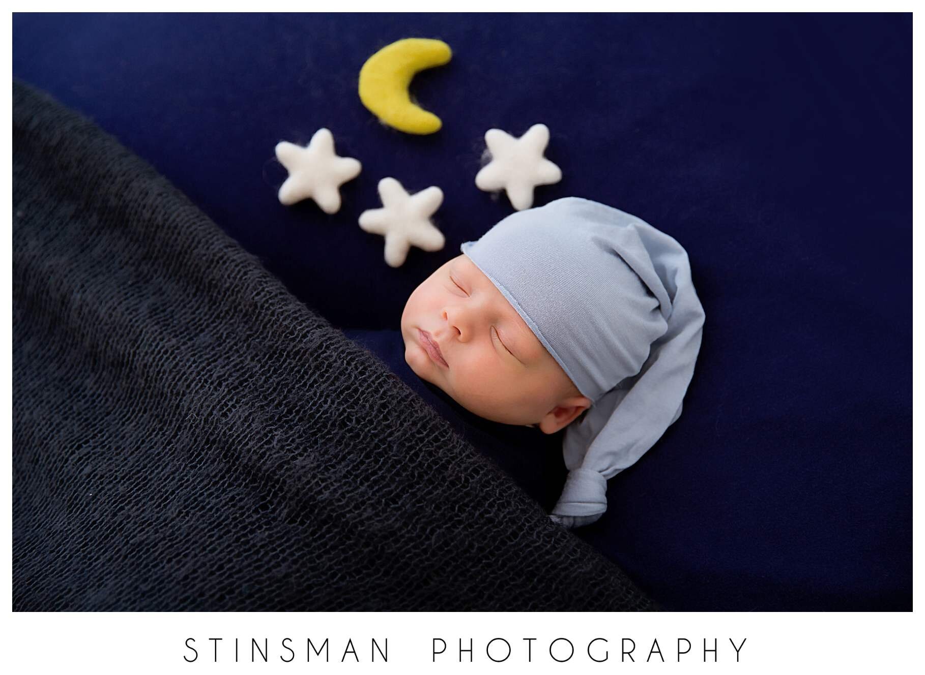 sleeping-baby-boy-wrapped-in-navy-blue-with-moons-and-stars.jpeg