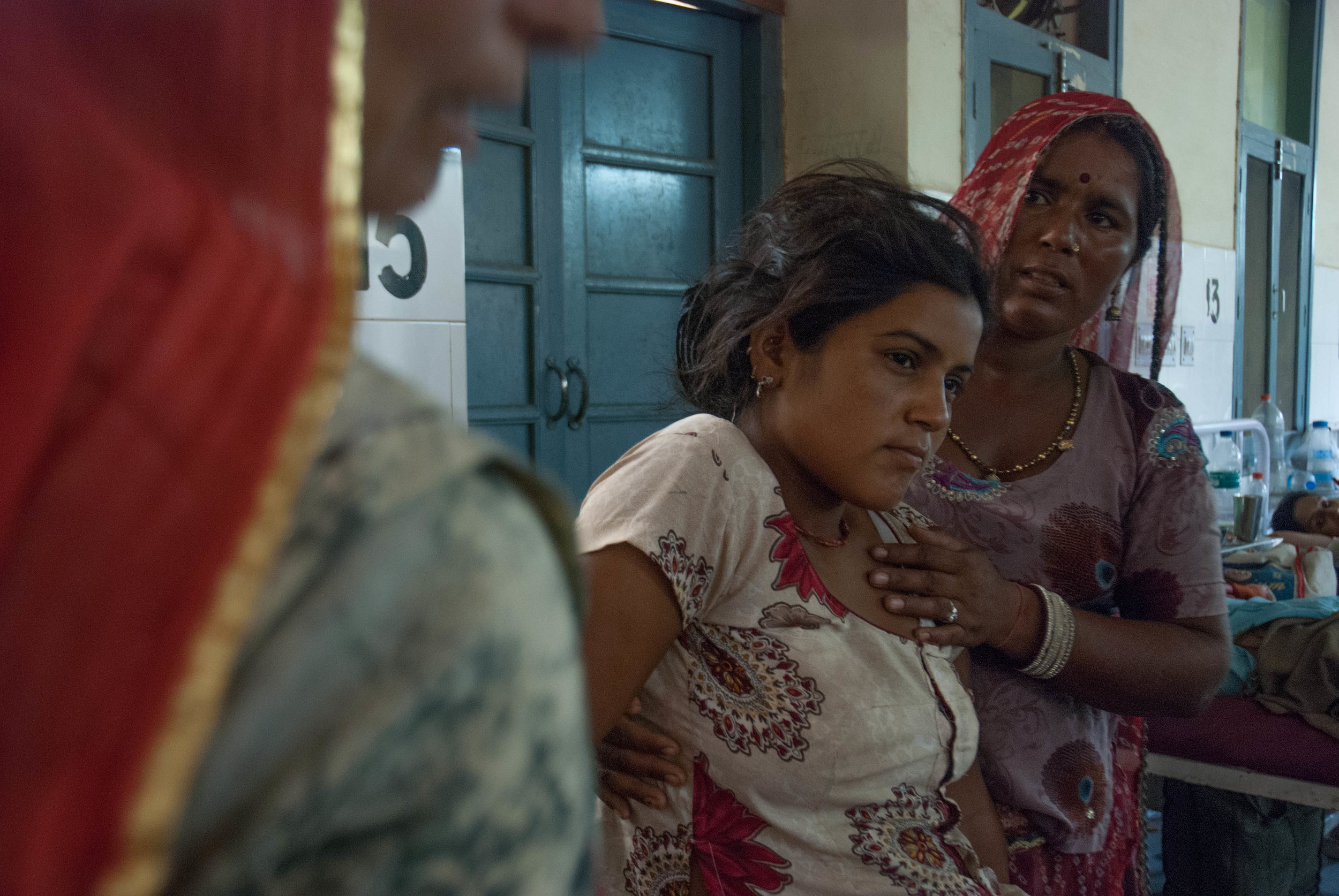  A young teenage-mother is taken care of by her mother and aunt after a successful delivery. They wait in the maternity ward for the baby to return from the necessary vaccination shots, all covered by the Free Medicine Scheme. 