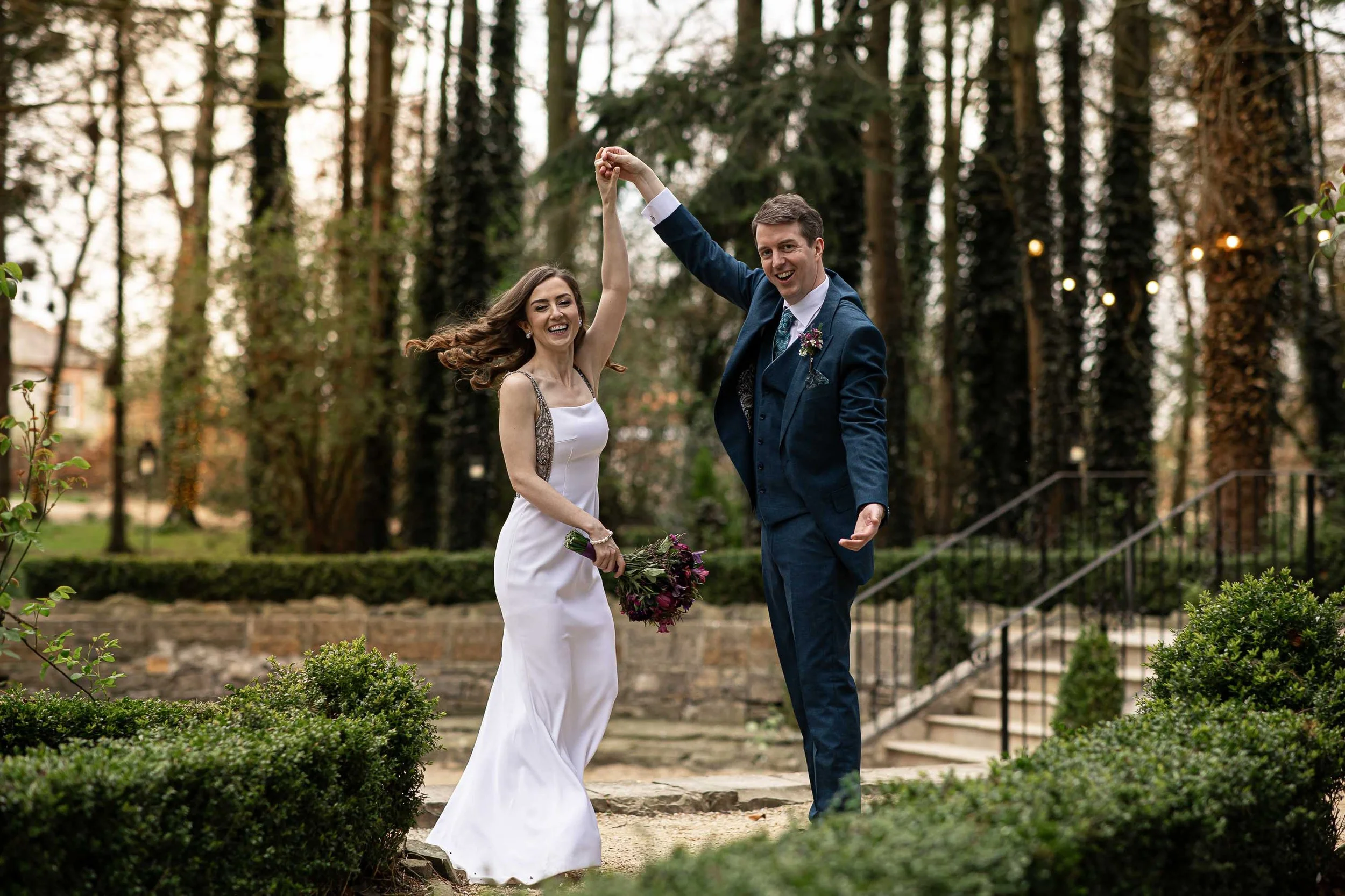 A bride and groom share a dance at the Station House Hotel. Golden sunlight surrounds them as the laugh and smile on their happy day.