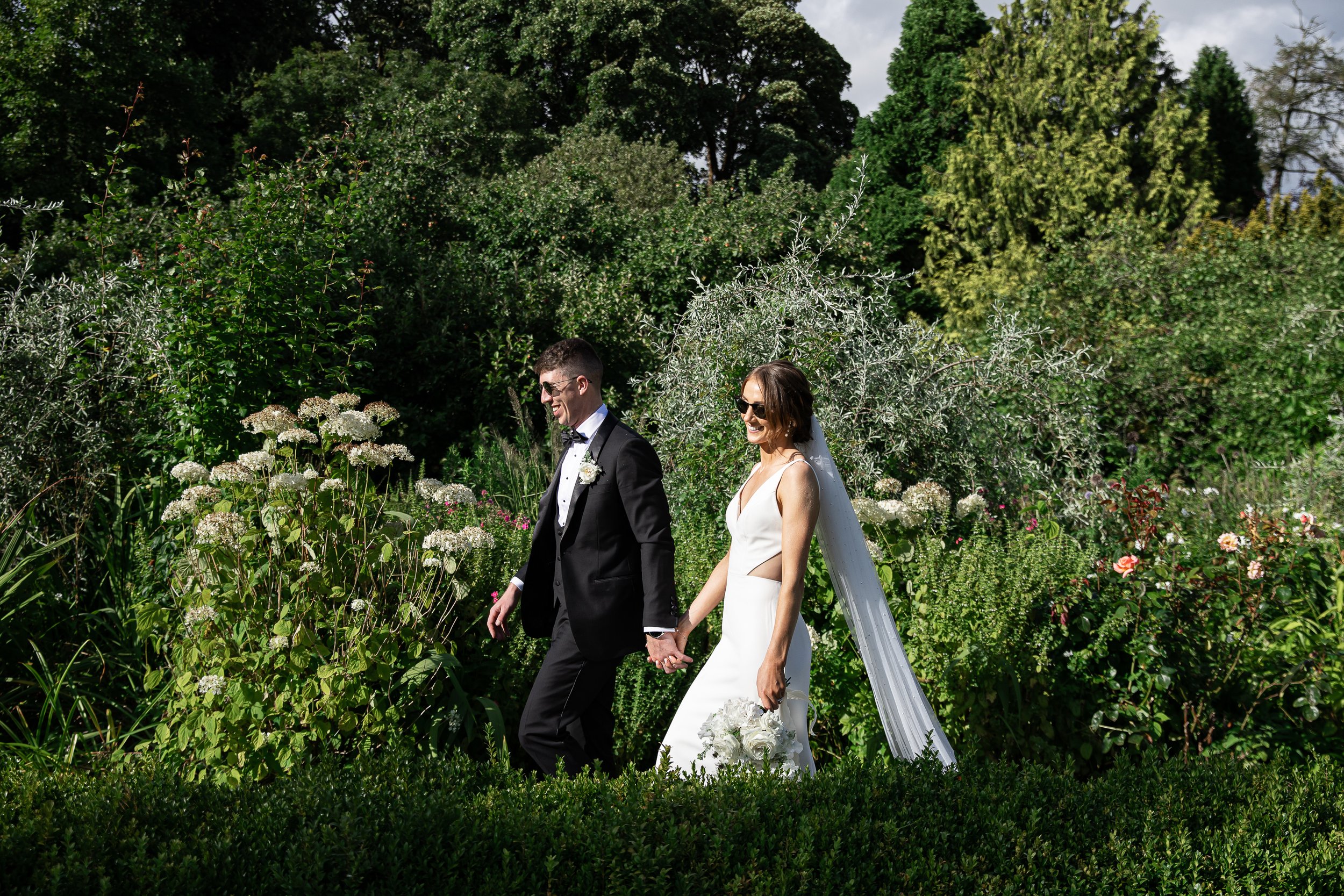 Newly wed couple strolling trhough the grounds of Rathsallagh House enjoying the sunshine and splendid surroundings of the County Wicklow countryside.