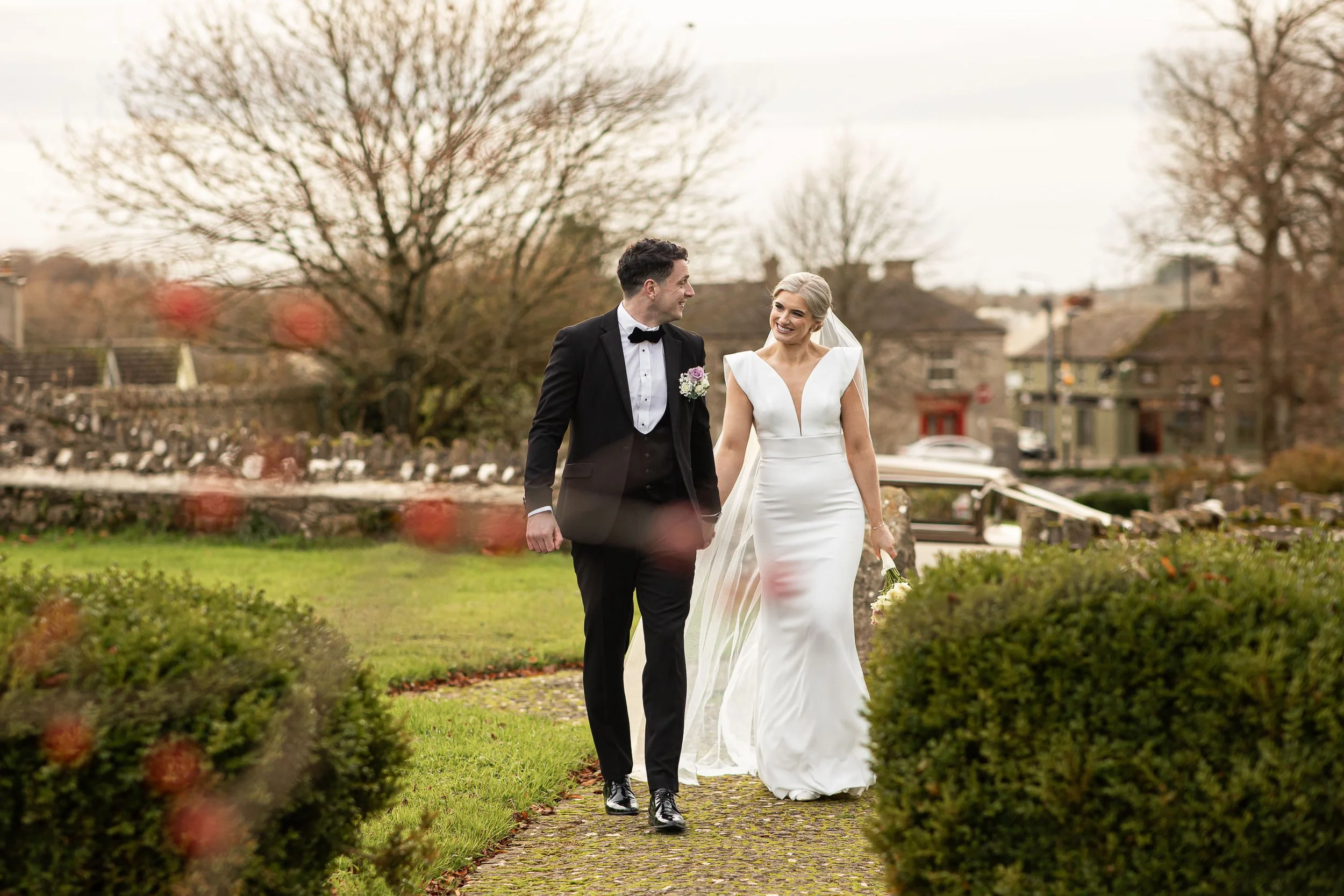 gowran-abbey-bride-and-groom-walking-hand-in-hand-folkster-gowns-kate-tobin-liam-ryan-wexford-senior-hurler-donal-o'connor-oc-wedding-videography-daragh-mccann-stargaze-photography.jpg
