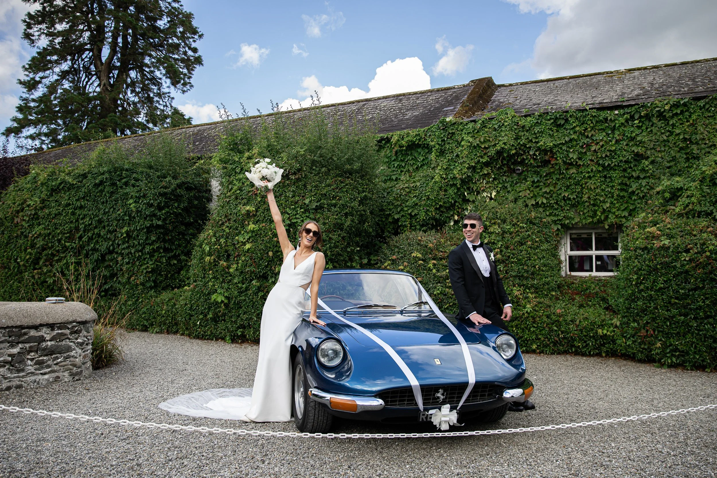 Wedding couple celebrating with a blue vintage Ferrari at Rathasallagh Country House, Kilkenny, photographed by Daragh McCann of Stargaze Photography.