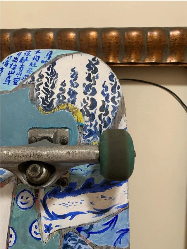 Image Description: Close up of painting on top portion of skateboard.