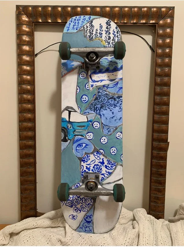 Image Description: Photo of a skateboard that is painted in shades of blue and brown porcelain style patterns.