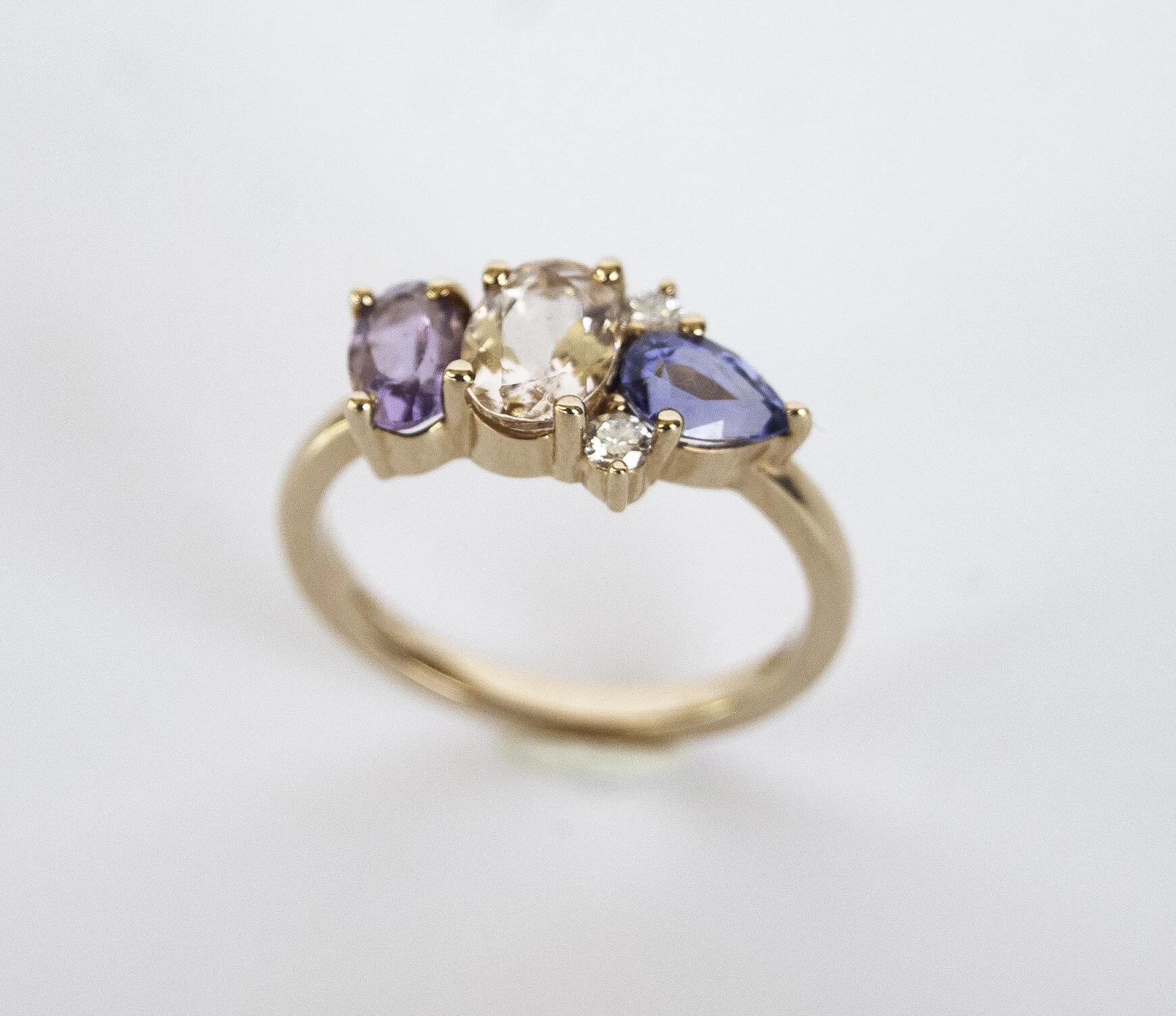 200-913 14 Karat Rose Gold 3 Stone Fashion Ring Size 6.25 one 0.70ct Oval Morganite, one 0.40ct Oval Amethys, one 0.58ct Pear Sapphire 2=0.08tw Round Diamonds $1,863.00