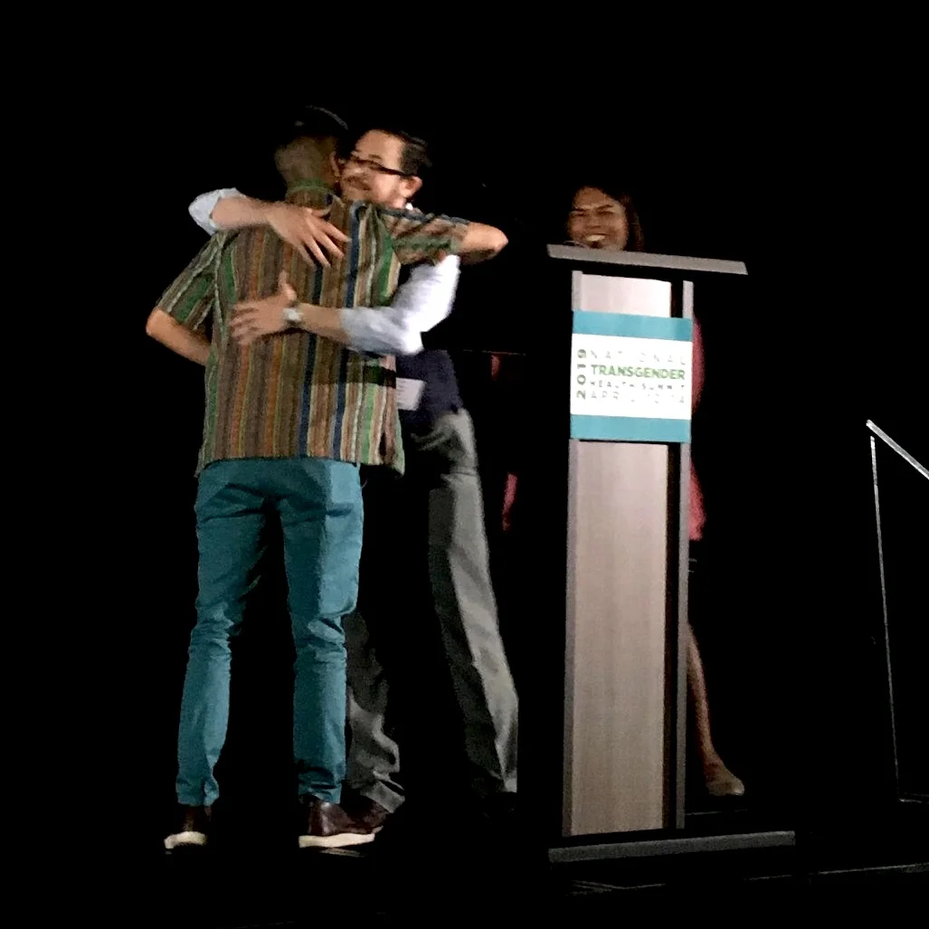 Seth and Tố hug at the speakers' podium