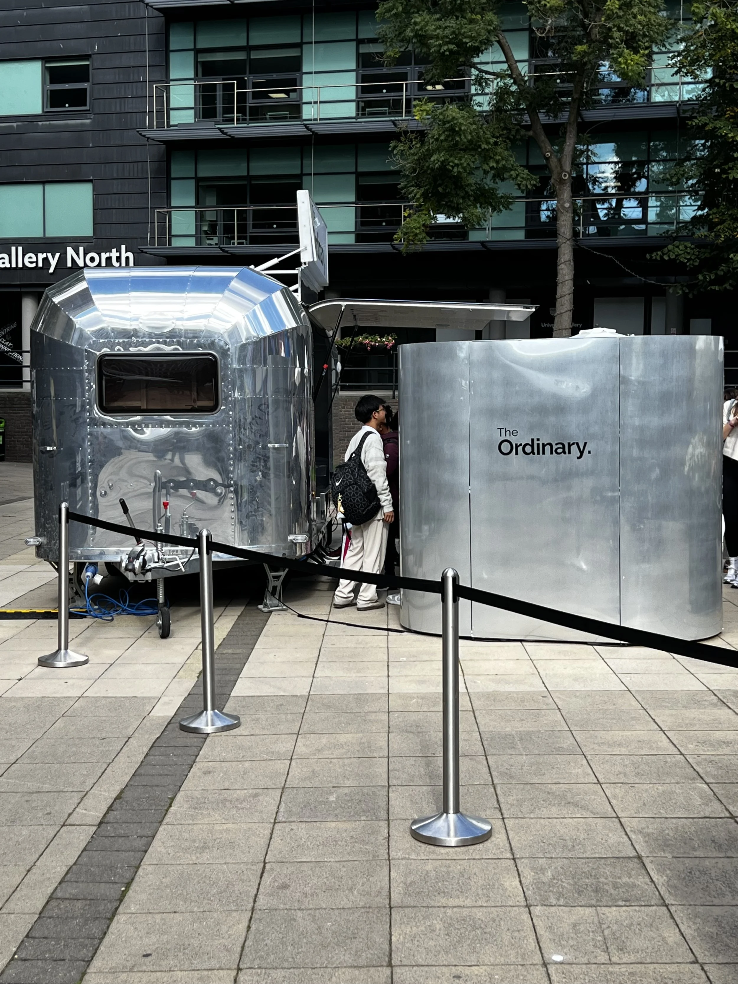 A brand promotional outdoor experience with a fully branded photo booth in brand colours alongside an air streamer.