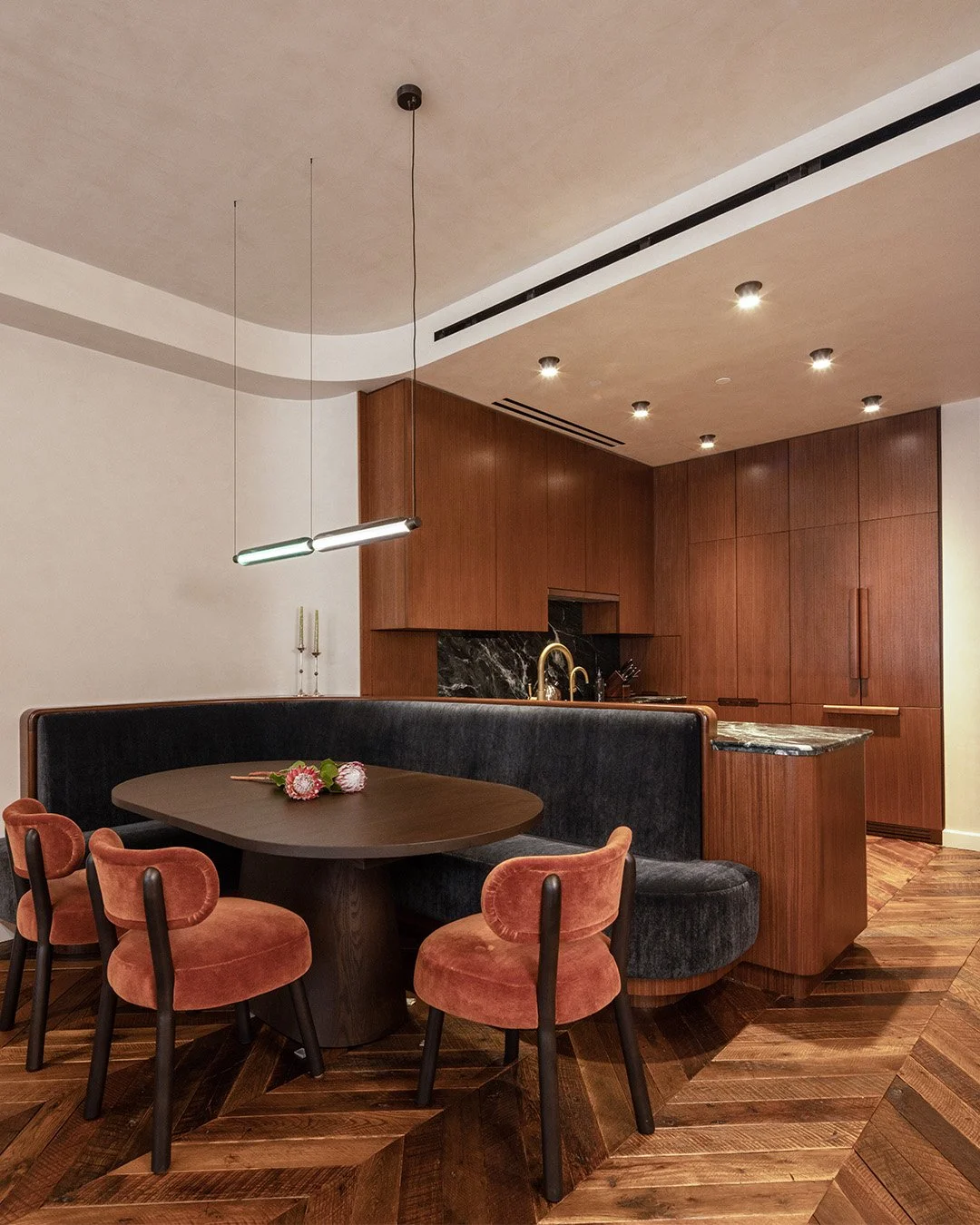 In this SoHo penthouse duplex, a rich and layered material palette carries into the kitchen and dining area, where a curved plaster ceiling meets walnut cabinetry and dark stone counters. 

Starting with minor plan modifications, Shadow optimized the