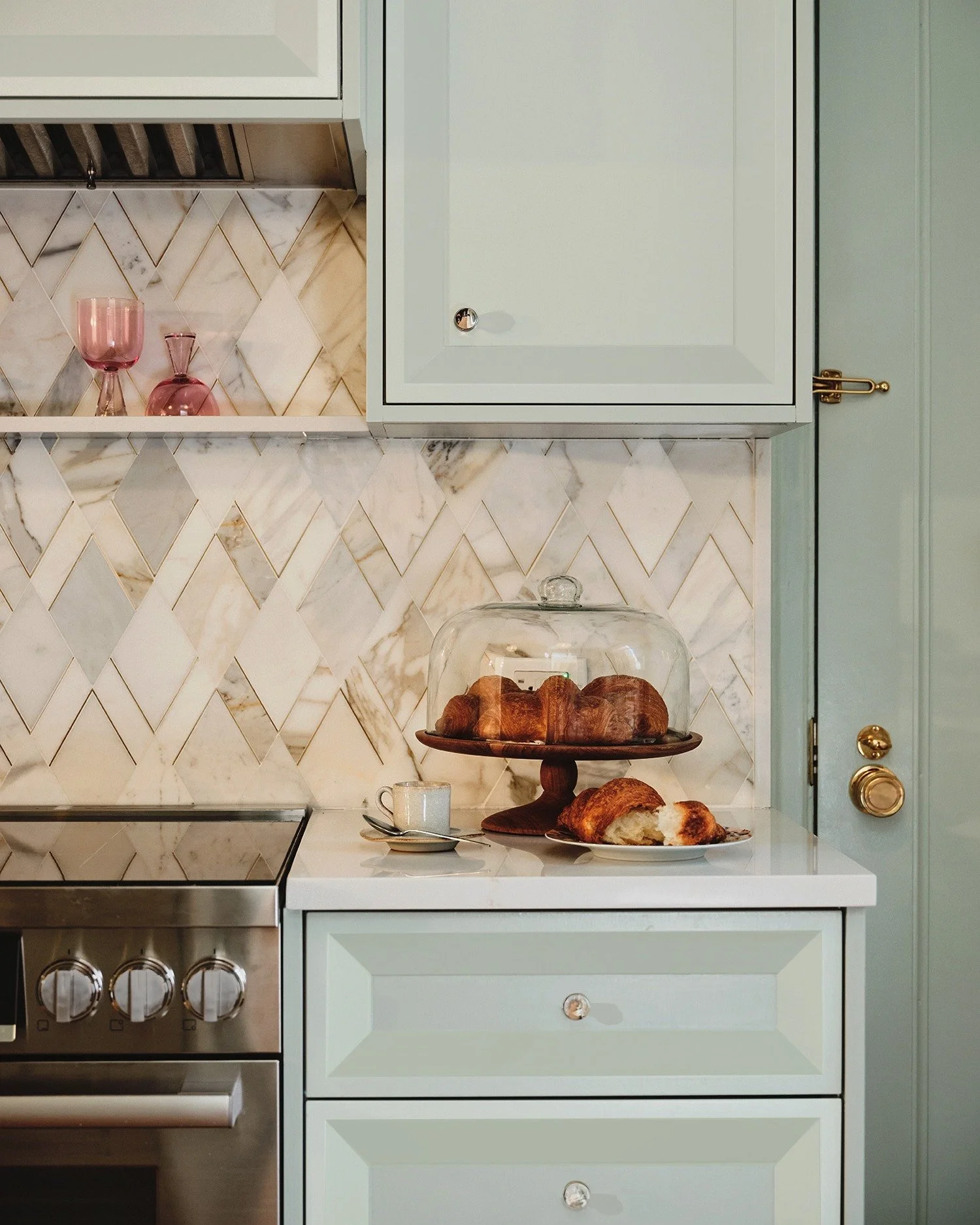 At this Upper East Side Townhouse, the kitchen got a full reset: All-new cabinetry with a cheeky nod to 1960s Hollywood Regency style, painted a just-right pale blue to tie the whole design together.

Next door, the eat-in kitchen area centers on a c