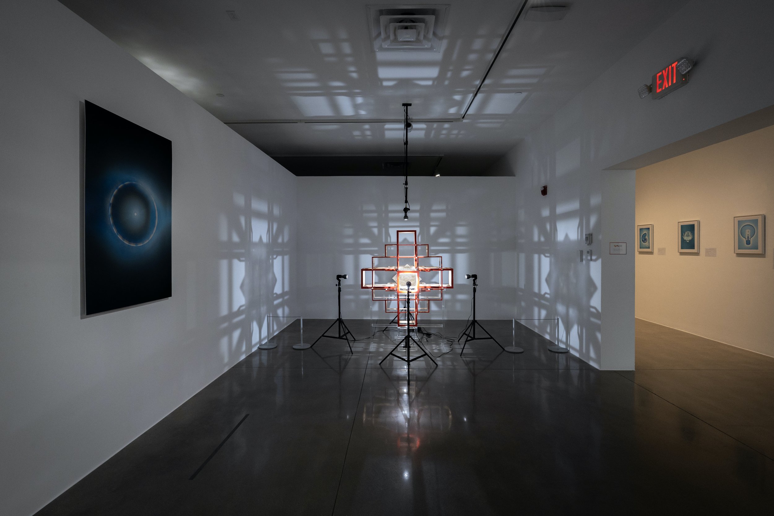  left to right:  lejos (afelio) , 2025, archival inkjet print, 48×30in;  photosphere , 2025, light, mica, acrylic on ponderosa, 48x46x46in  installation photography by L.A. Art Documents, courtesy of Lancaster Museum of Art and History 