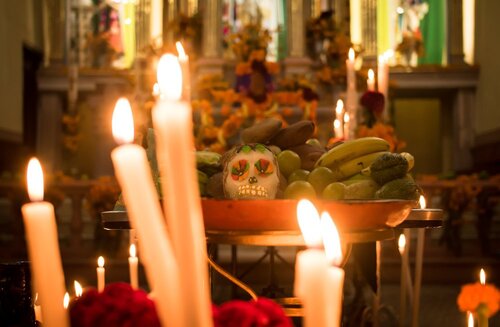An altar often features a photo of the deceased and is surrounded by flowers, candles, and different kinds of food and beverages.