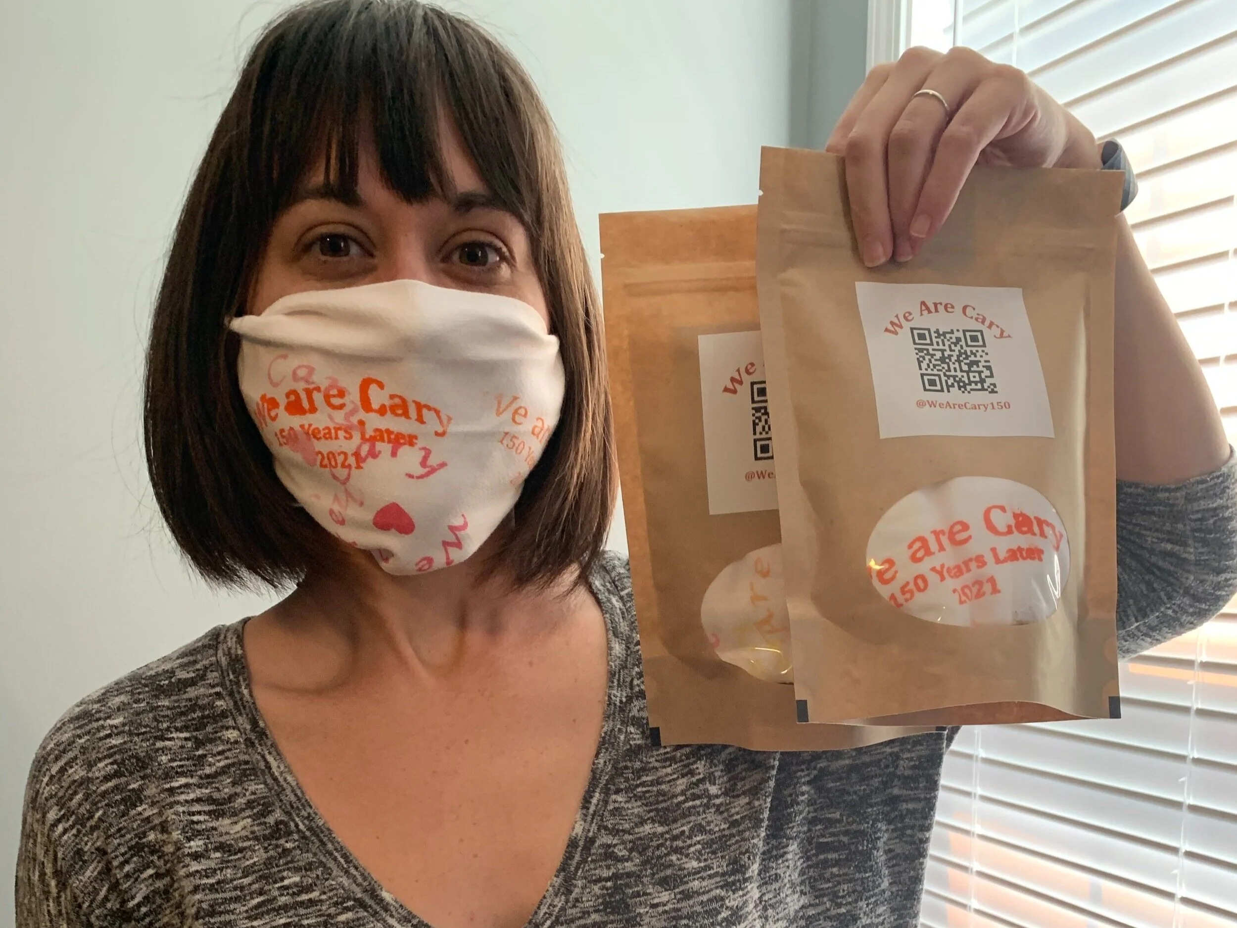 Project member holding up masks to delivery to community members.