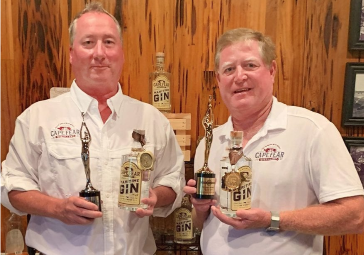 Cape Fear Distillery owner Alex Munroe and distiller Rick Neisler are pictured with awards for the company’s Maritime Gin. Contributed photo