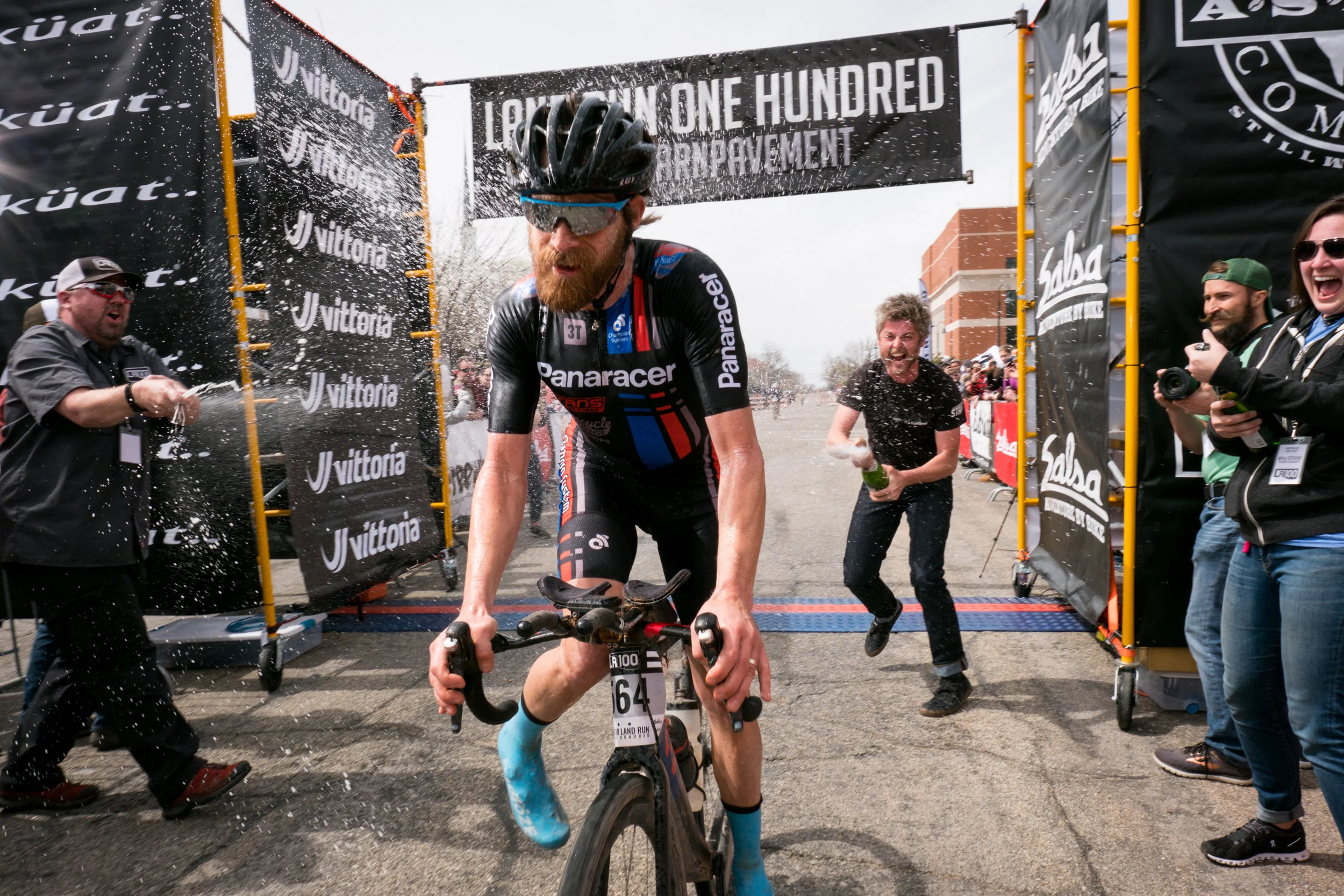 2018 winner Mat Stephens crosses the finish line in a champagne blitz
