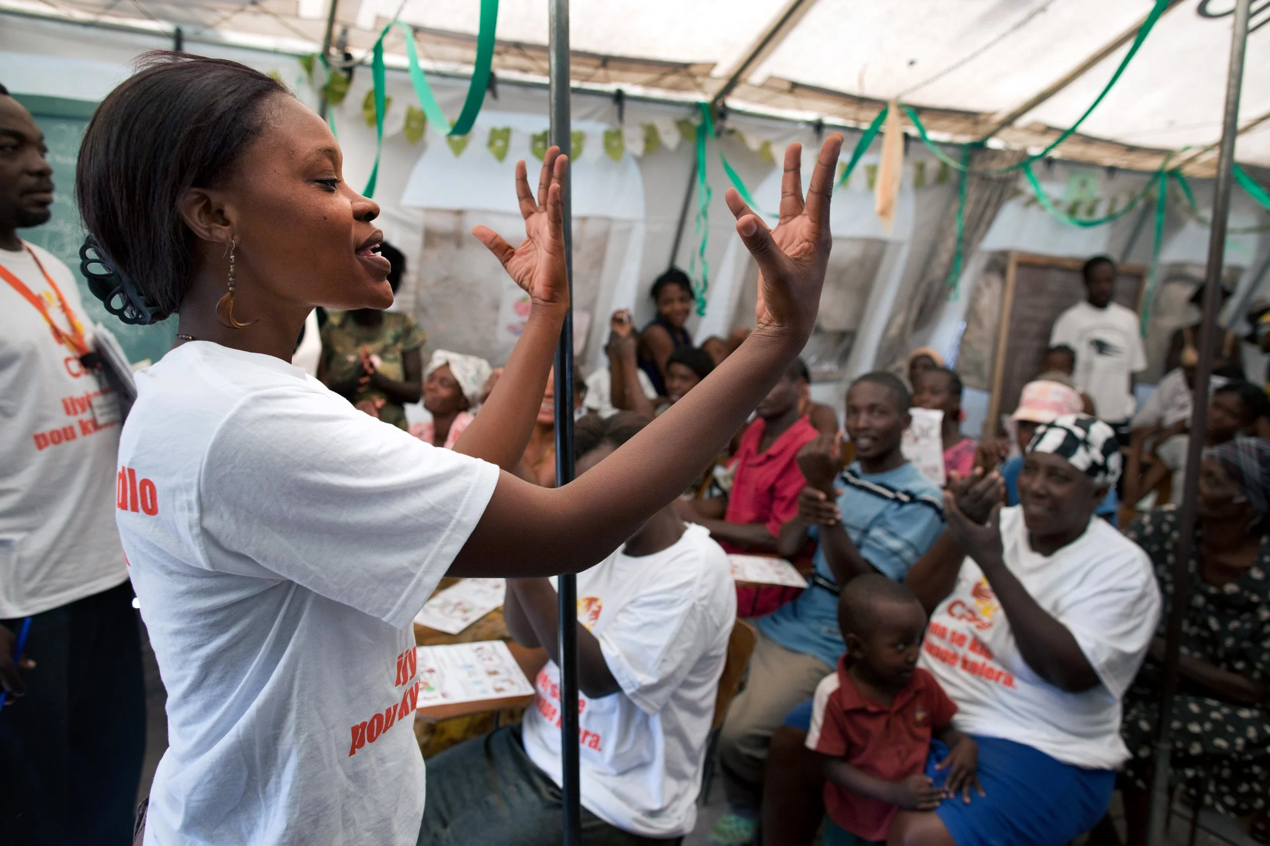 Magdala St. Ange, a member of the CARE WASH team (water and sanitation) demonstrates good hand washing technique at a hygiene workshop