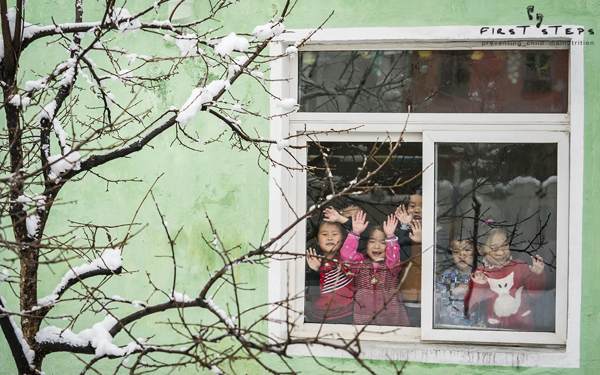 Children look through the window at the Yangji Daycare.