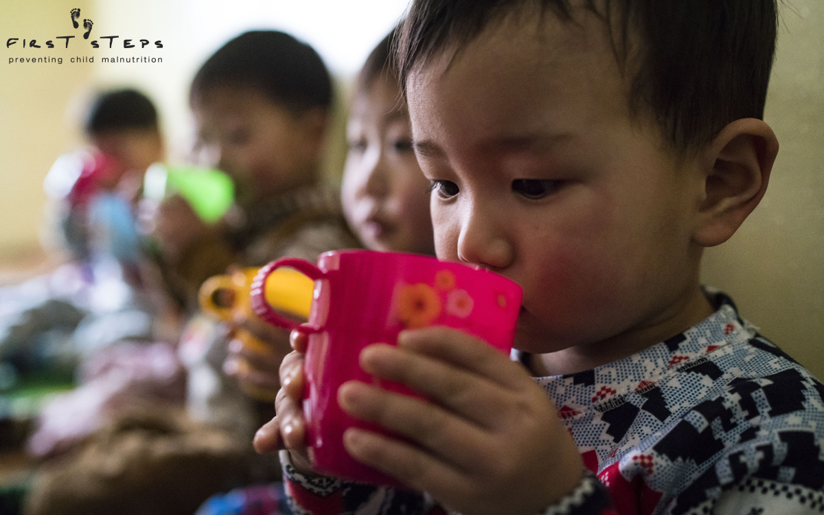 Careful sips of warm nutritious soymilk at the Yangji Daycare.