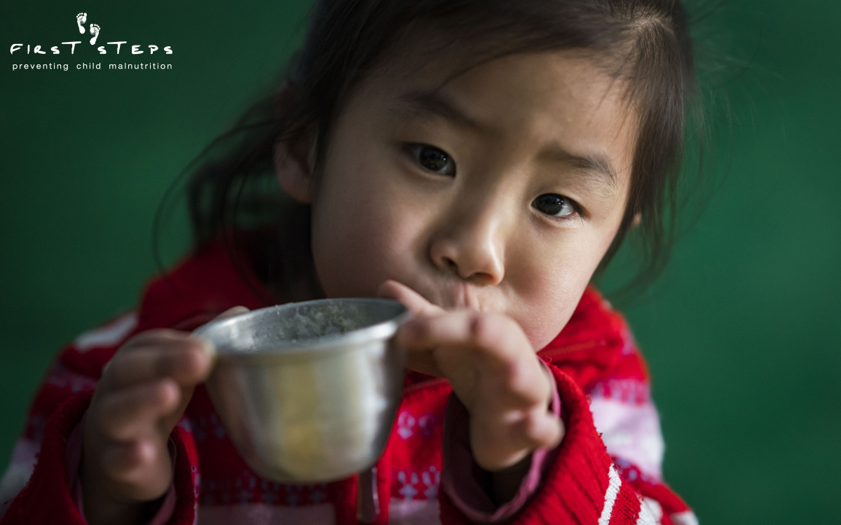Due to a lack of electricity, the workers at the Sopo #2 Mobom Daycare must grind soybeans by hand to make the soymilk for the children