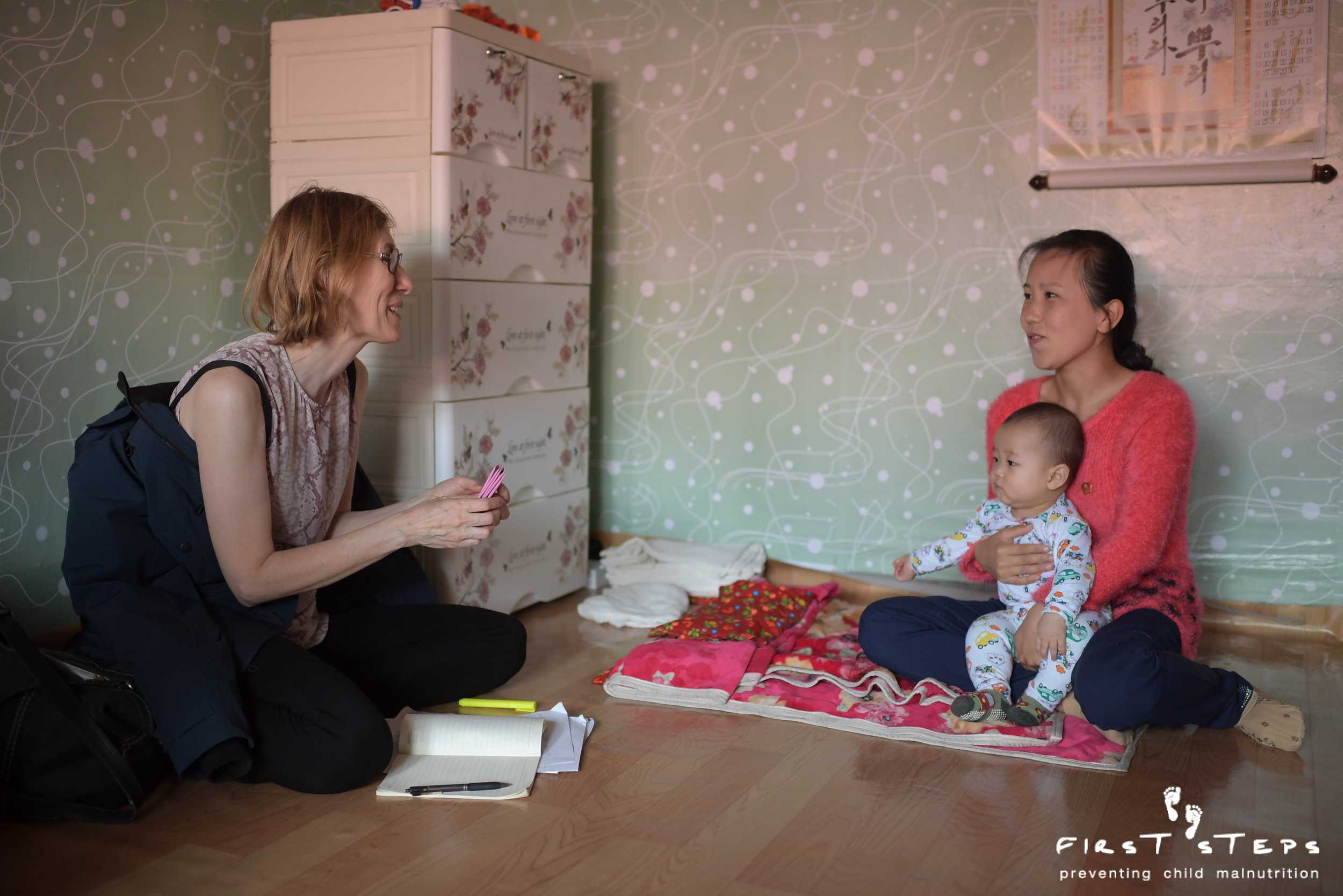 Susan Ritchie, First Steps’ executive director, visits the home of Sprinkles recipient Mun Kum-Hae and her six-month-old son Kim Whi-Bok.