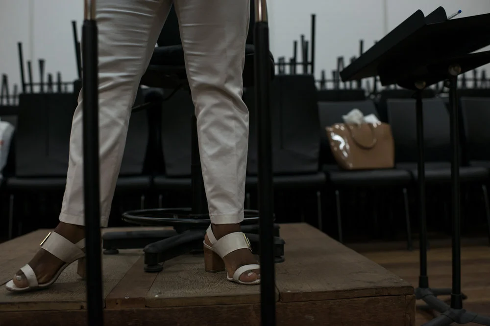 Dez. 5, 2017. Durante o ensaio da Banda de Concerto (cordas, metais e sopros) na sede do projeto, é possível observar a vaidade da maestrina. Está sempre arrumada, com unhas pintadas, batom, cabelos cuidados, sapatos com salto e acessórios que condizem com seu estilo feminino. "Se na África os negros eram reis e rainhas, eu sou uma rainha!", brinca Sarah, nome que vem do hebraico e significa princesa.