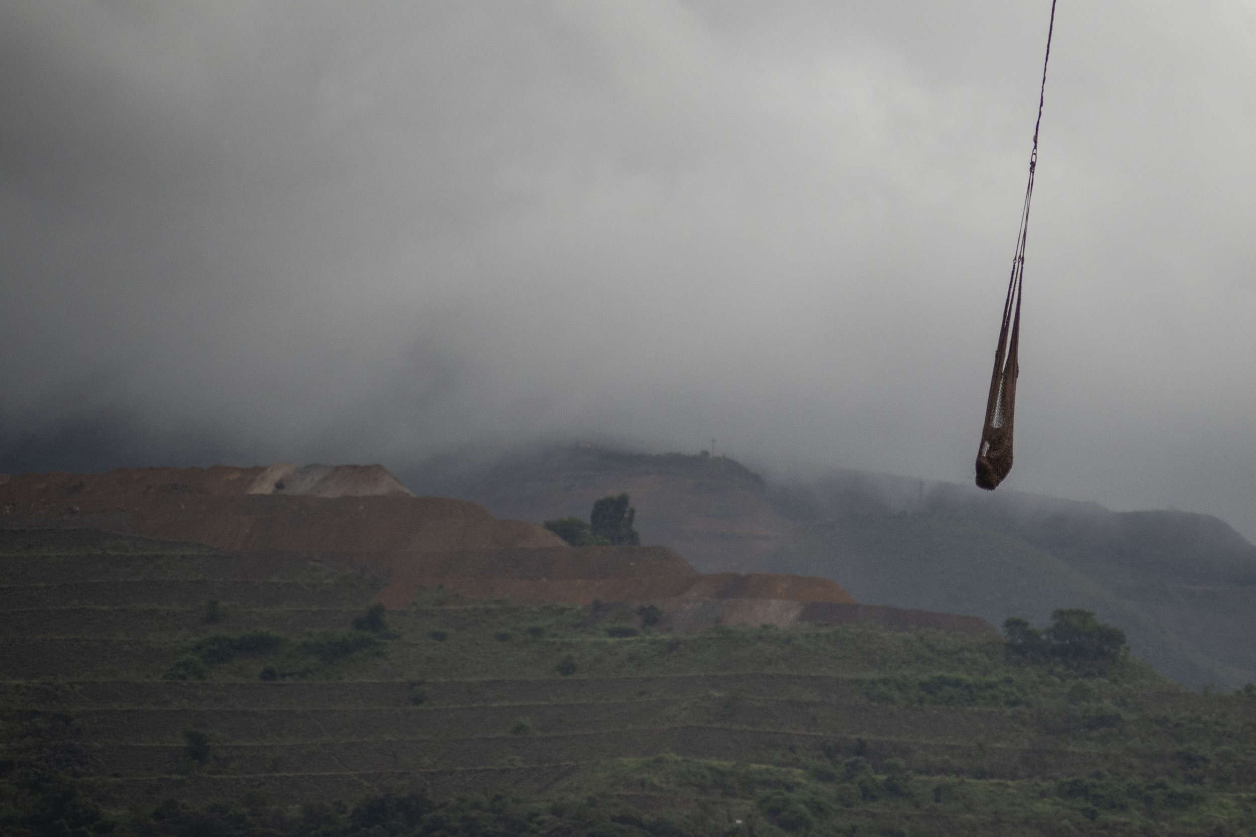  A rescue helicopter carry a body in a basket, in Parque das Cachoeiras area, Brumadinho. 2019 © LUCAS LANDAU 