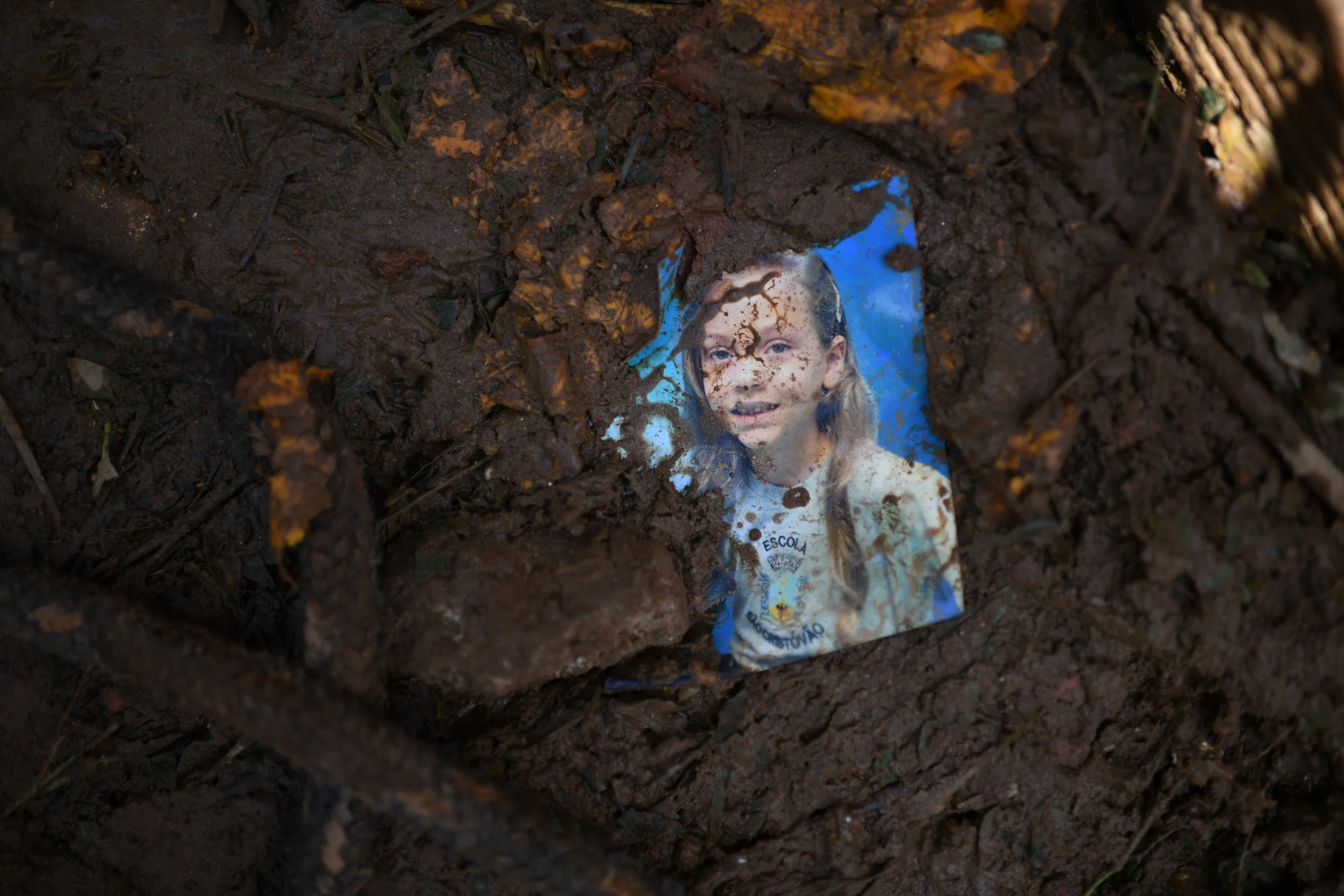  O retrato de uma criança no meio da lama. Havia muitos objetos pessoais espalhados por onde a onda de lama passou. Eles ajudaram os parentes a achar possíveis vítimas soterradas. 17 Fev, 2022. 